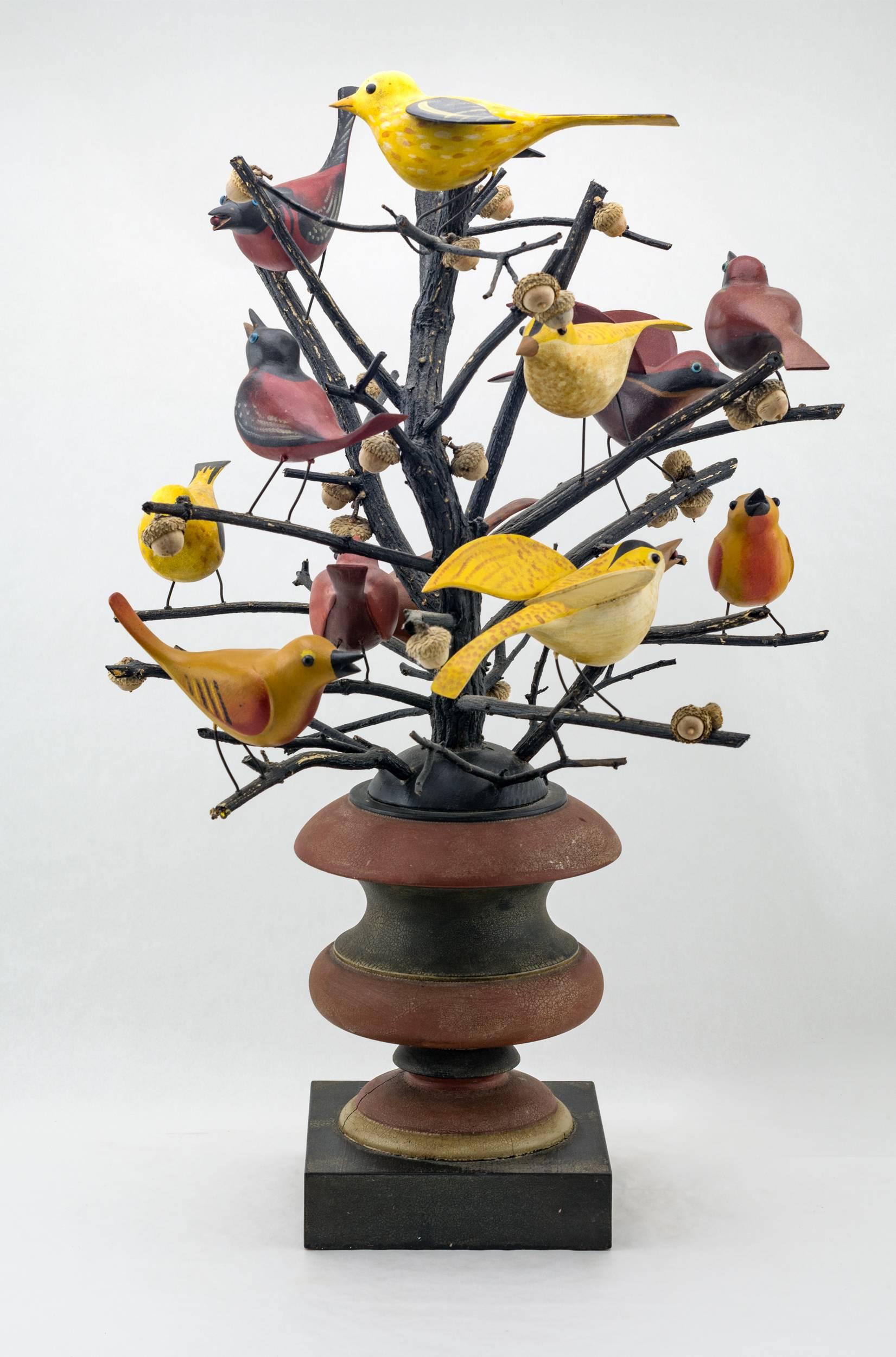 A total of eleven songbirds are perched on natural painted tree branches. Three of the birds with carved open wings, natural acorn shells are also wired to the branches. Mounted on a turn painted base. Unidentified signature, dated 1997.