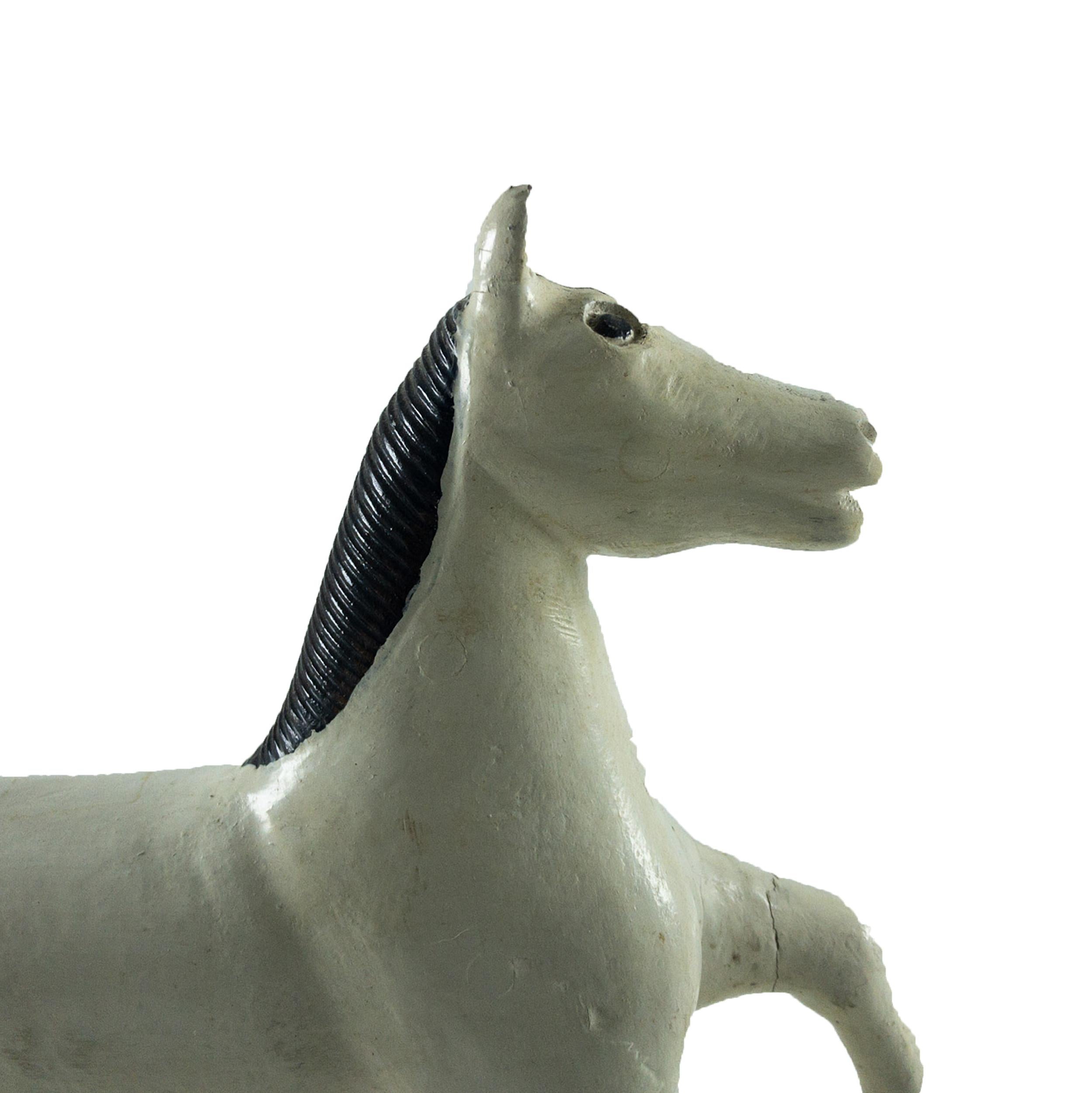 Painted white wooden toy carved in a walking position with glass eyes and comb like carved black mane and tail. Well carved and in great condition.
  