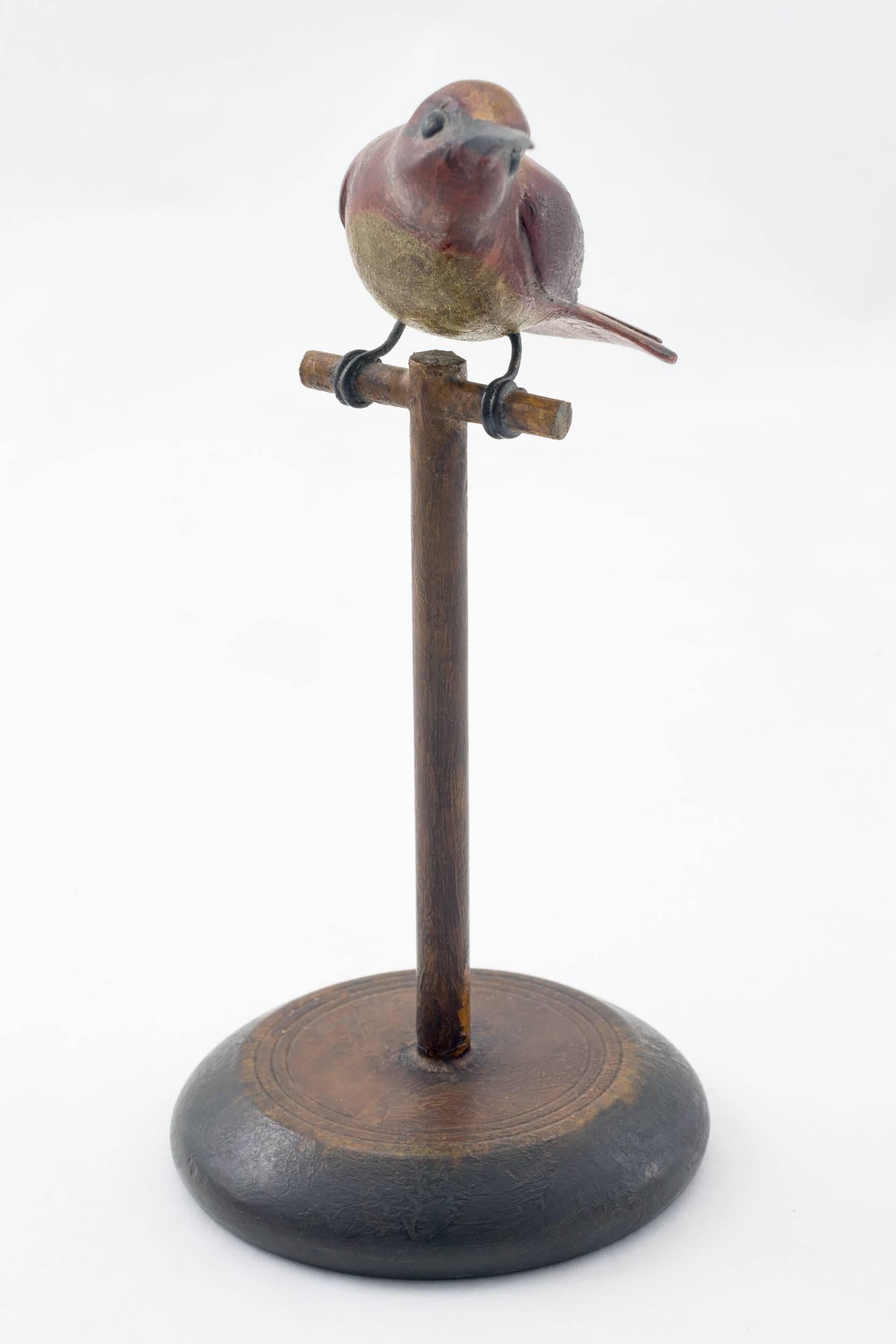 Carved and painted pine hummingbird, with wired legs and perched on a pedestal. Signed in script on the bottom of the base 