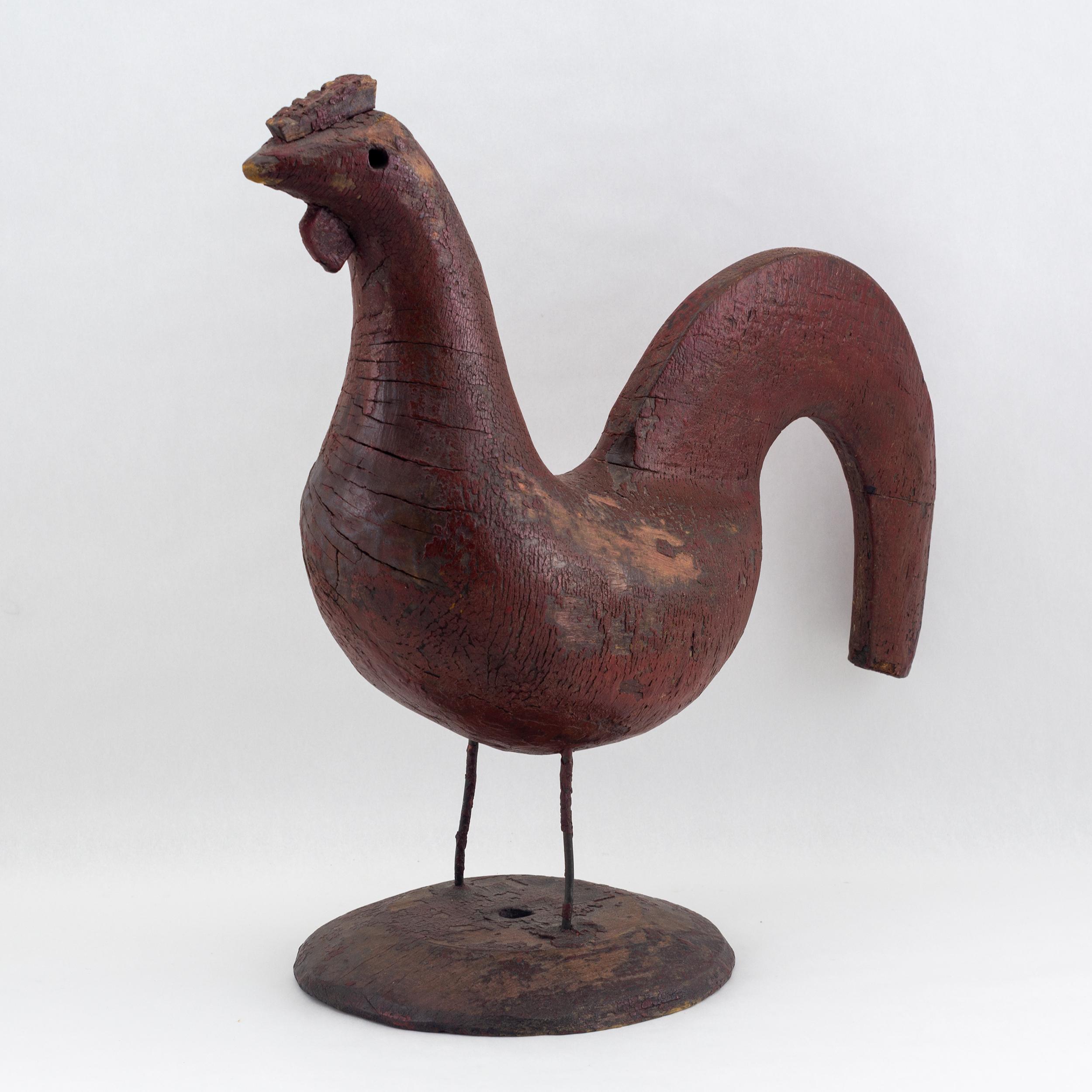 Red-painted Rooster figure with applied comb and waddle on wire legs 
in original condition. Sitting on a circular stand. Canadian, circa 1880.
  