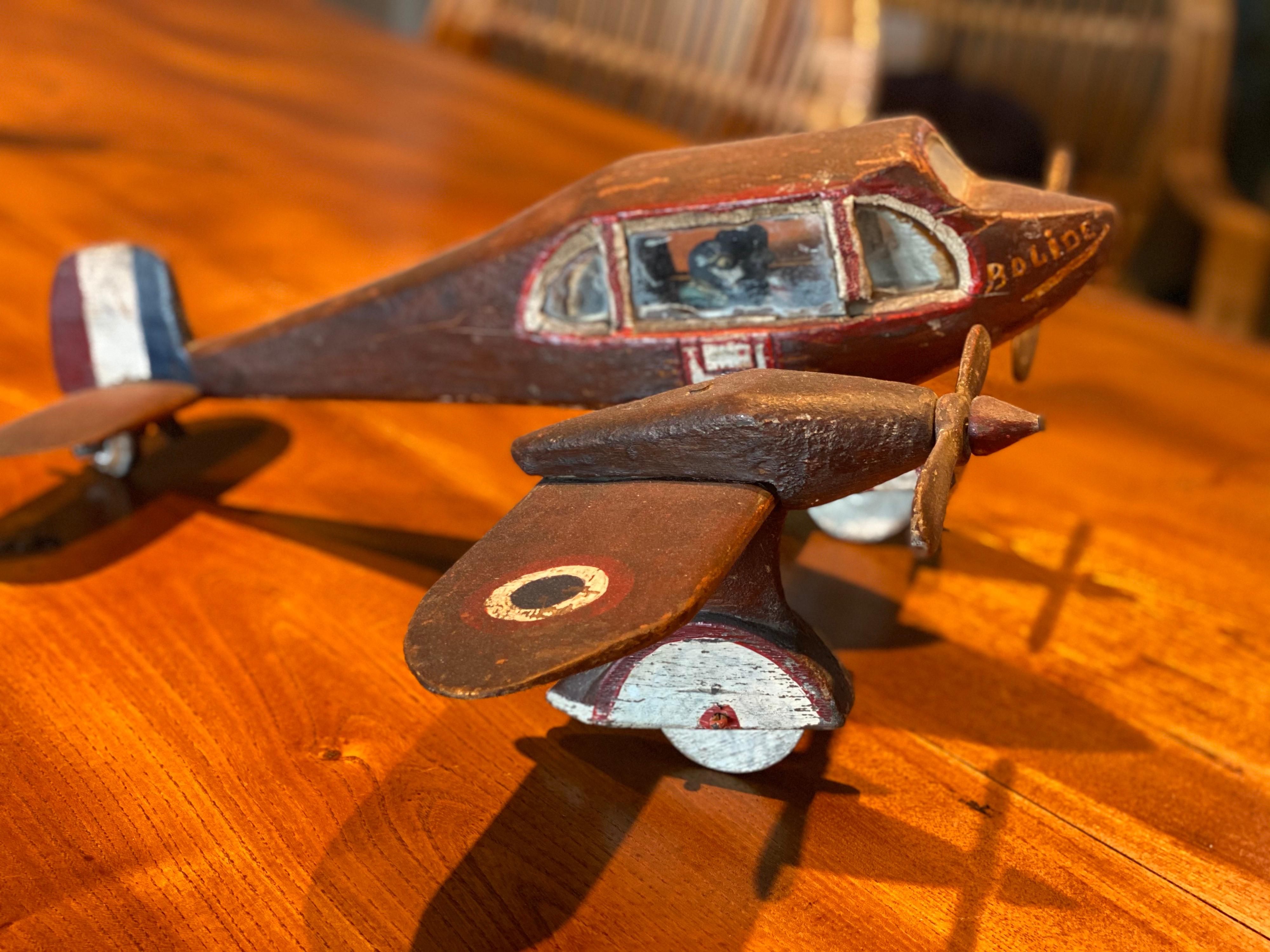 Carved and painted wood model of a French propeller plane, circa 1945
Painted in burgundy color with French flag colors on the tail. 
This handcrafted wooden french propeller plane is a great collectible piece as its attention to detail and