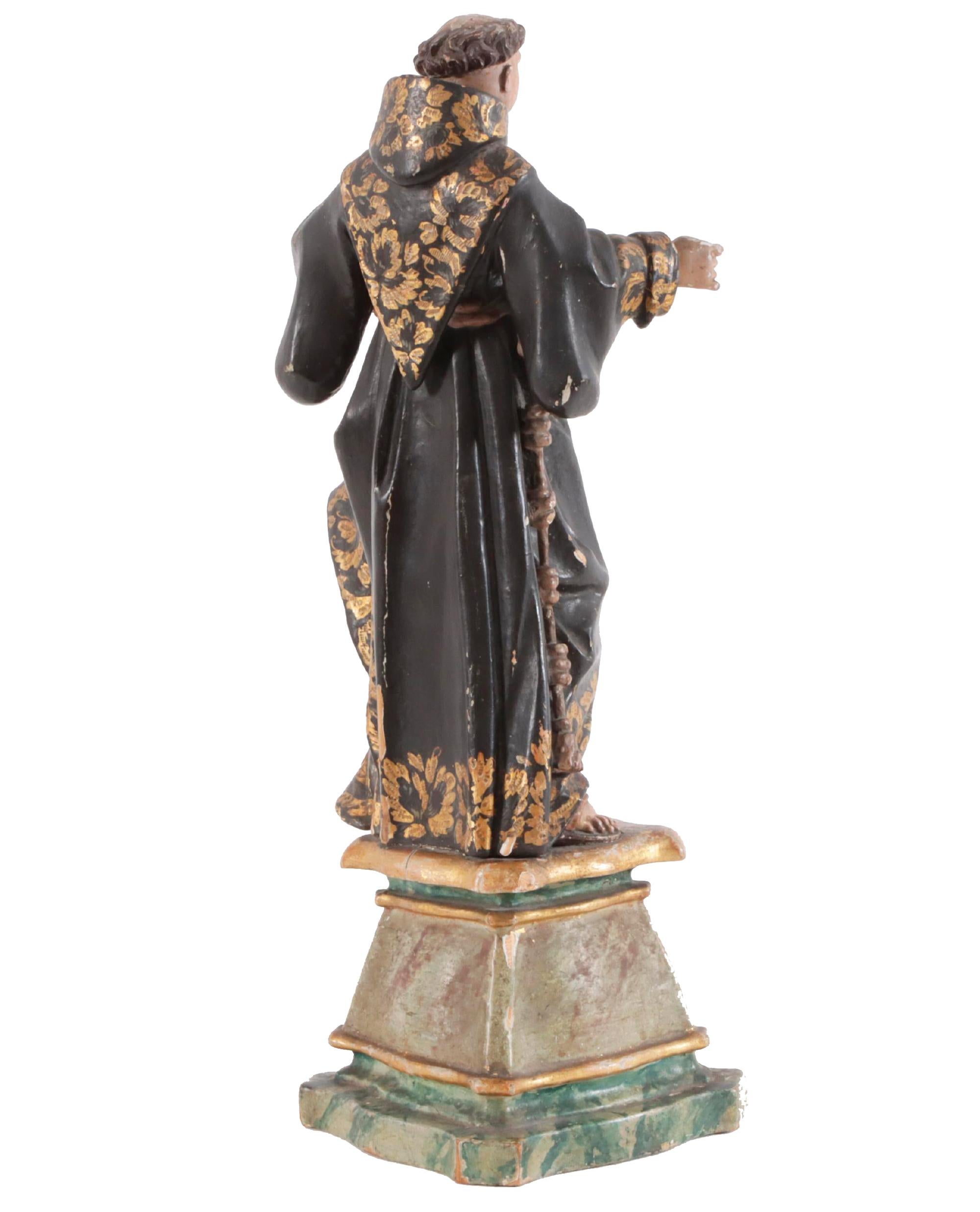 Carved and painted wood sculpture of a preaching monk, Spanish school, early 18th century. The sculpture features a monk situated on a piedestal wearing traditional cassock and sandals whilst holding the holy book. This monk can be seen in a larger
