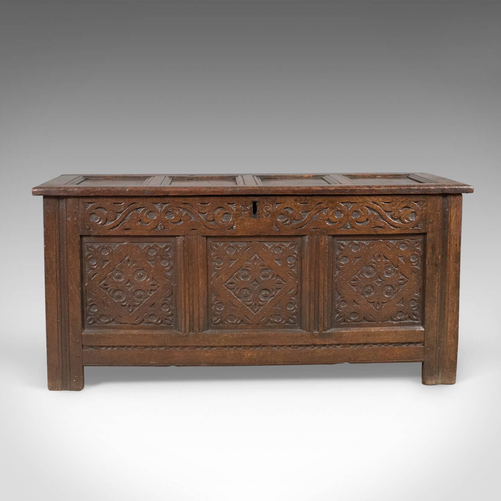 This is a carved antique coffer, an English oak joined chest dating to circa 1700.

Glorious color and desirable aged patina
Vigorously carved decoration to the front panels
Guilloché foliate frieze to carved central initials 'F S'
Over three