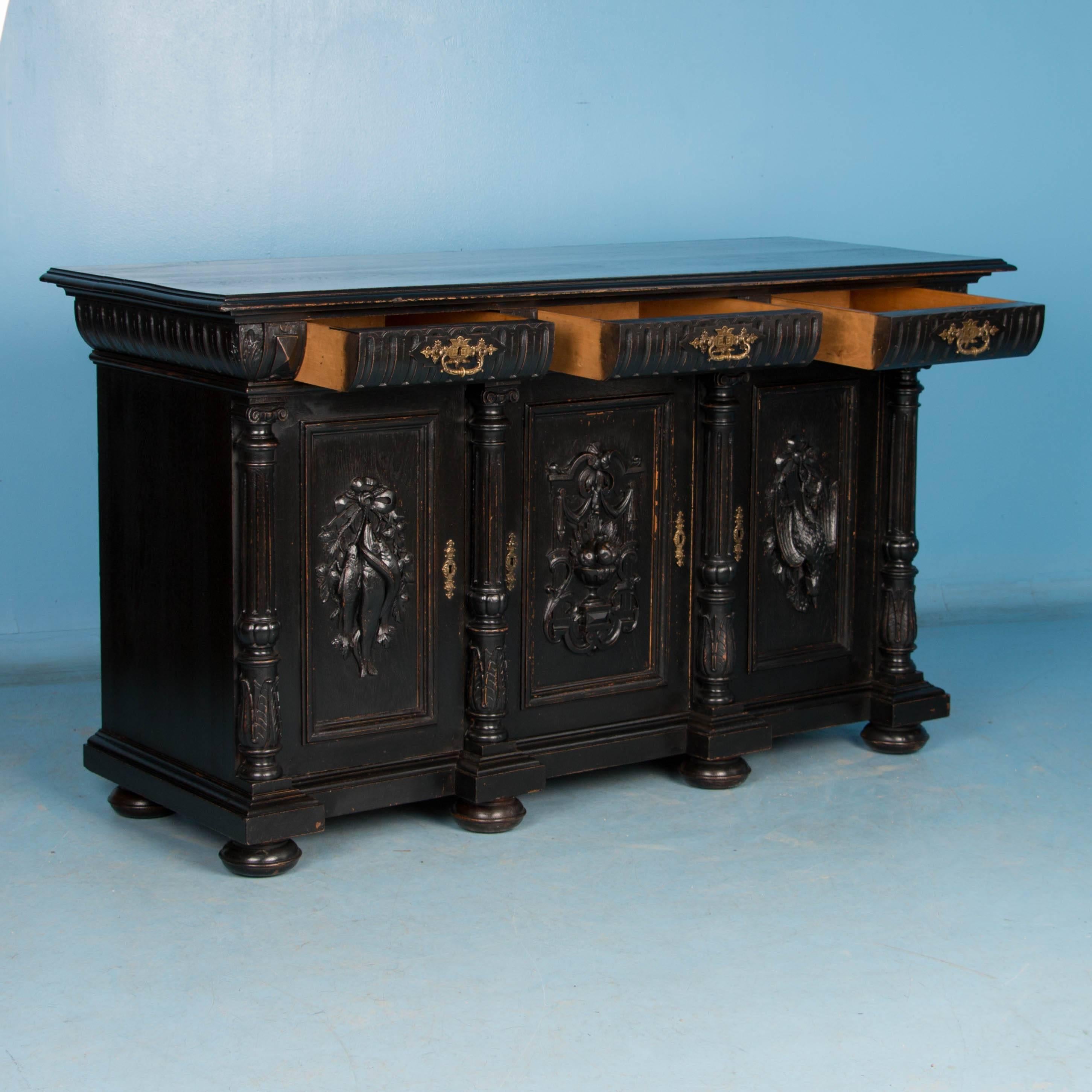 Dieses stark geschnitzte Sideboard aus dänischer Eiche hat mit einer schwarzen Lackierung neues Leben eingehaucht bekommen. Beachten Sie die geschnitzten Paneele im Schwarzwaldstil:: die gedrechselten Säulen und die Stollenfüße:: die dieses