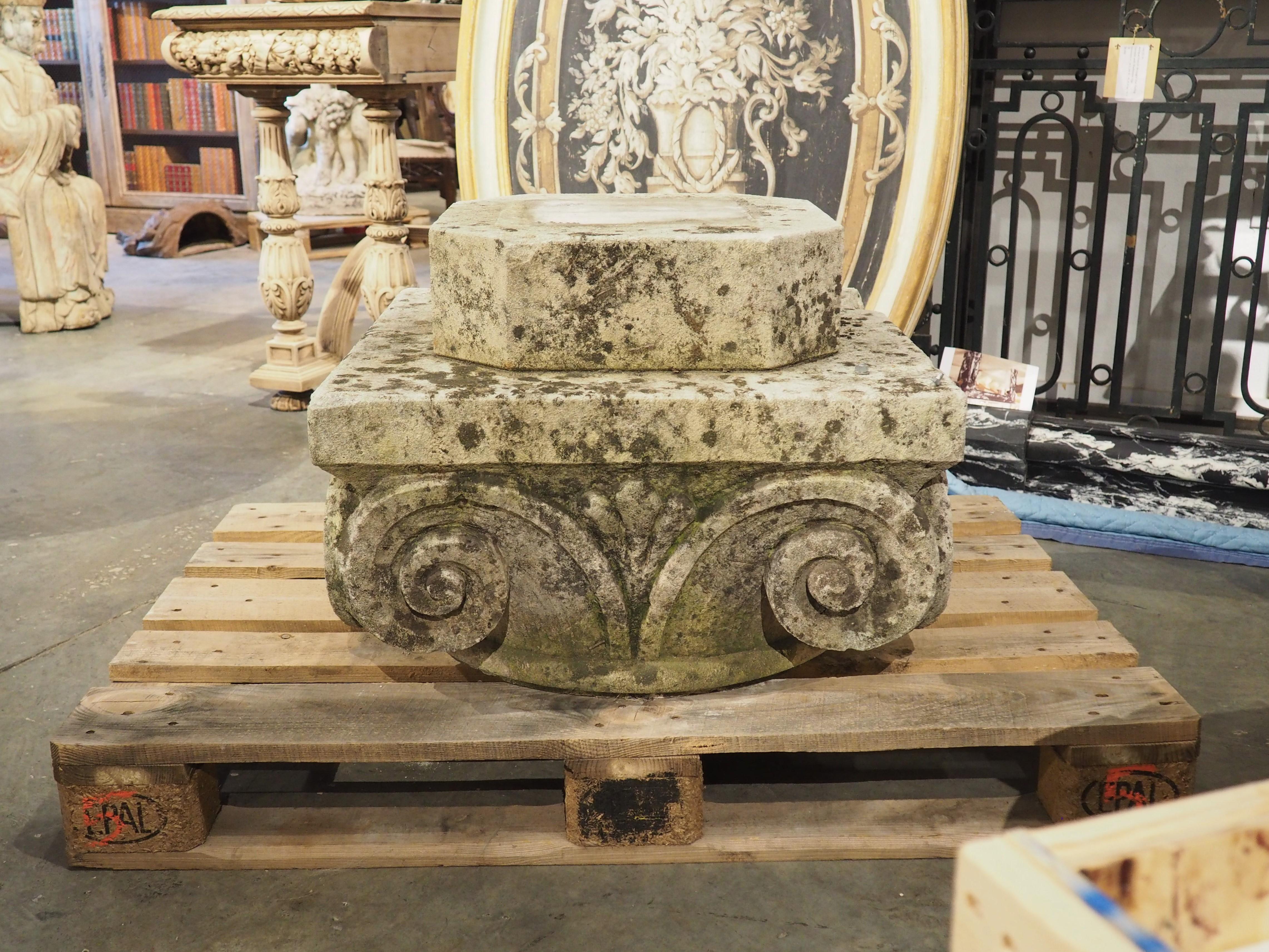 Hand-carved in France, circa 1850, this limestone pedestal was most likely the capital of an architectural column. Each side has been adorned with two tightly wound volutes, indicative of an Ionic order construction. It was not uncommon for Ionic