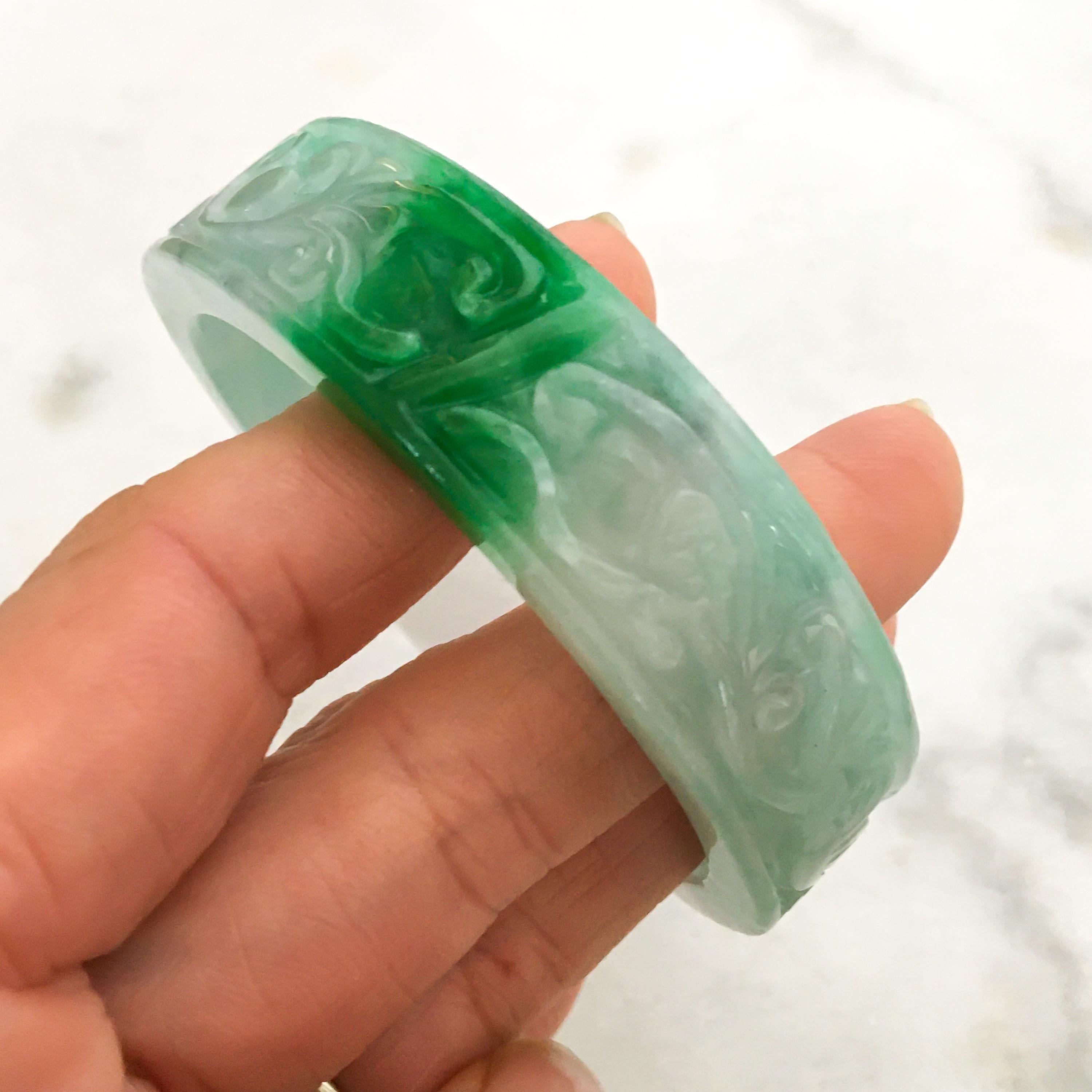 This natural jadeite jade carved bangle bracelet has a beautiful translucent mottled green and white color. This Burmese jade bangle is beautifully carved and dates from the 1950s-1960s. 

The bangle measurements - outer diameter is 75.3 mm, width