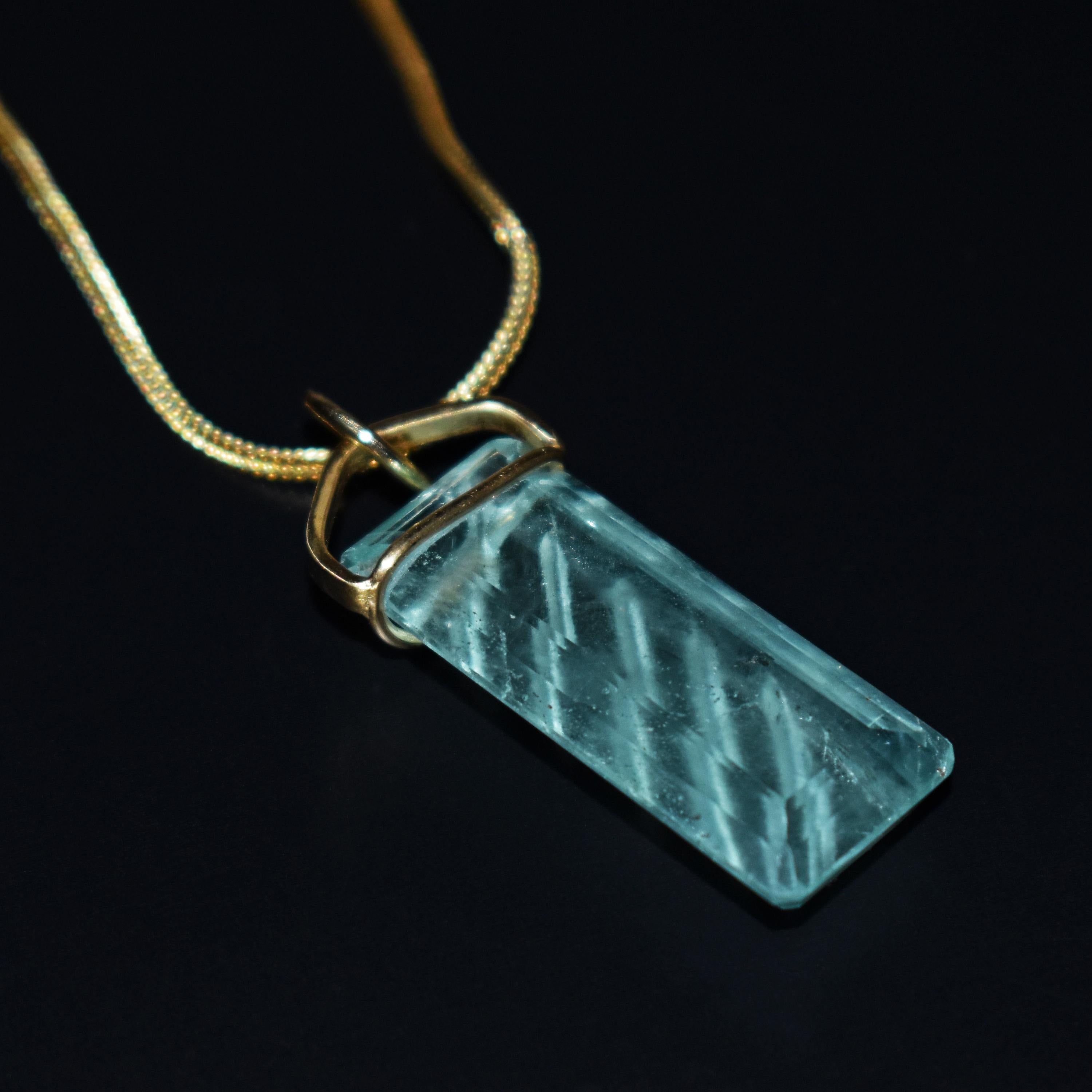 Beautiful hand-carved, emerald cut Aquamarine and 18k yellow gold pendant on a 16 inch 18k gold foxtail chain necklace. Aquamarine pendant, including bail, is 1.63 inches or 41mm in length. Unique carved line / stripe design in this seafoam greenish