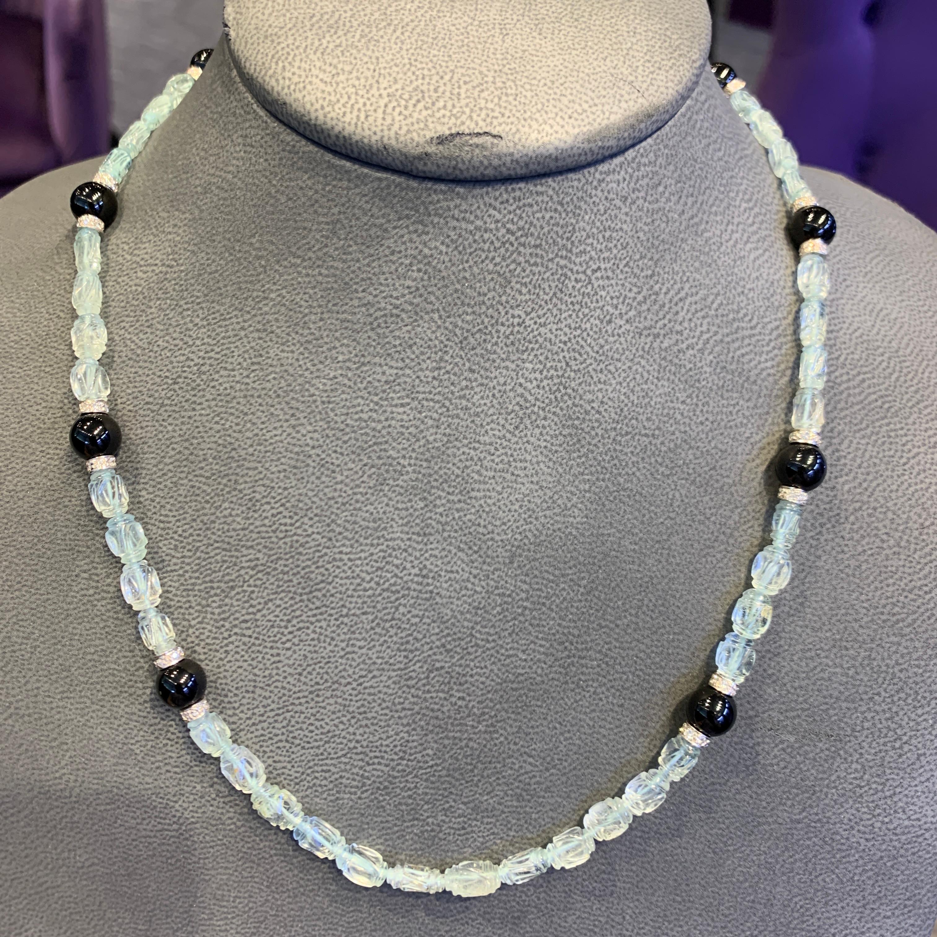 Collier de perles d'aigue-marine et d'onyx sculptées 

Collier composé de perles d'aigue-marine taillées et de perles d'onyx, avec entretoises en or blanc 14 carats et fermoir serti de diamants ronds taillés.

Longueur : 20