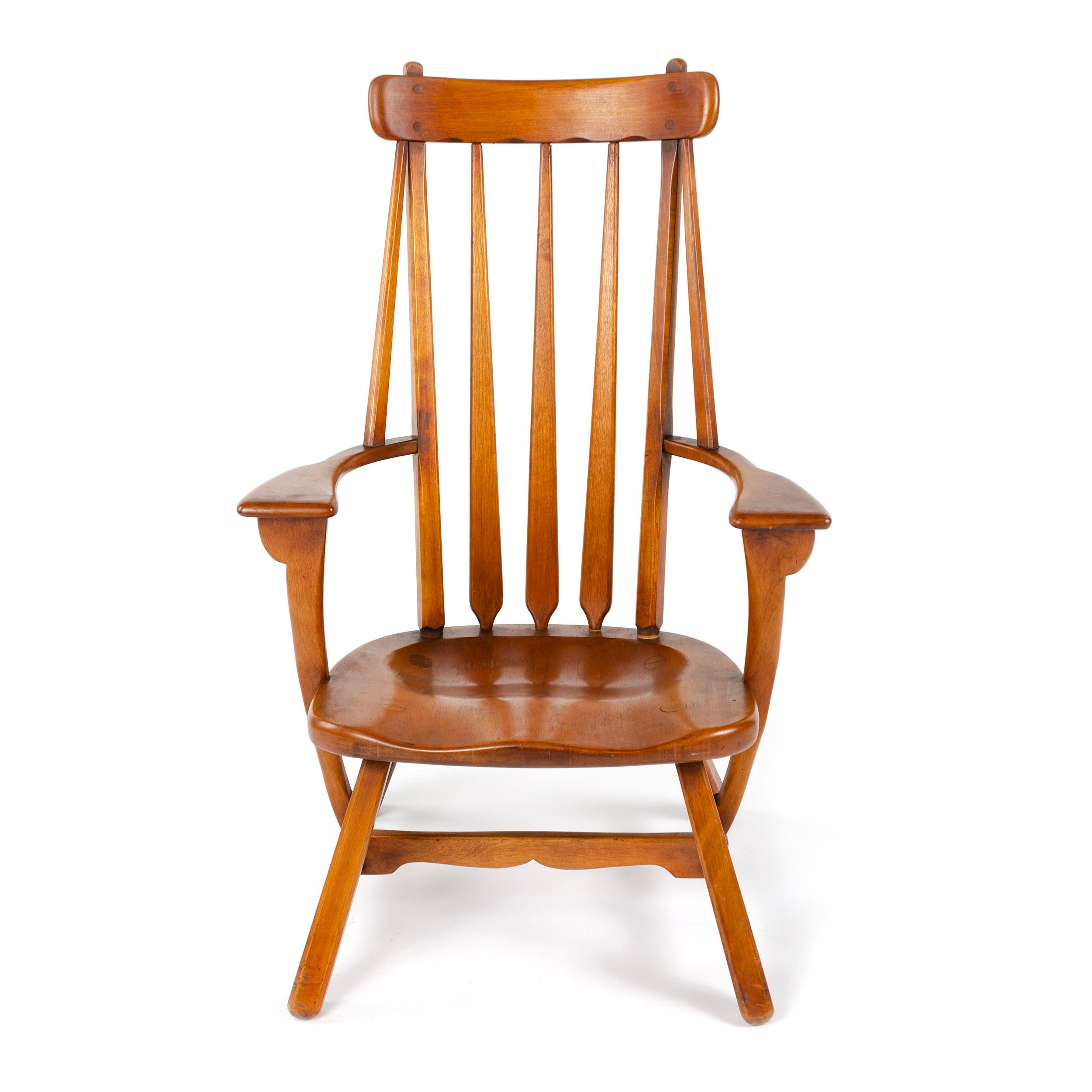 A masterful armchair in solid birch with hand hewn spindles and a curved lower cross arm.