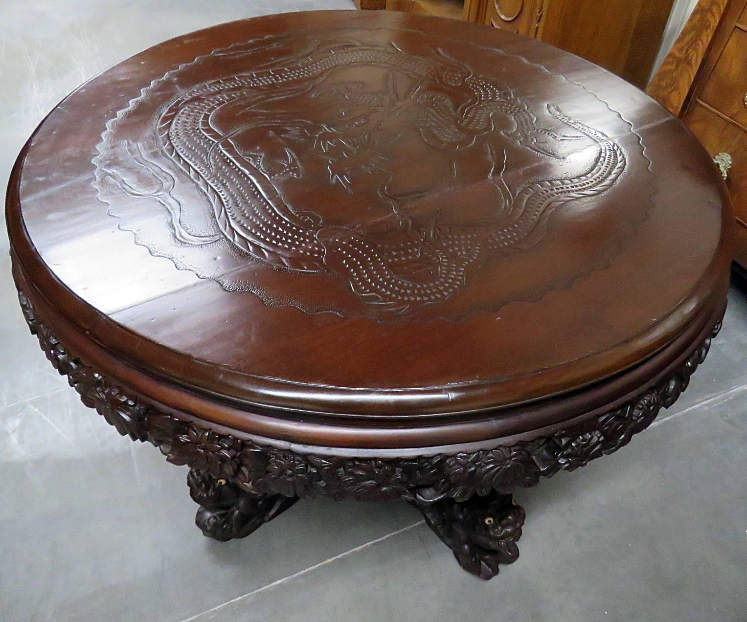 Intricately carved Asian center table. Beautiful dragon carved in to top with a foo dog base.