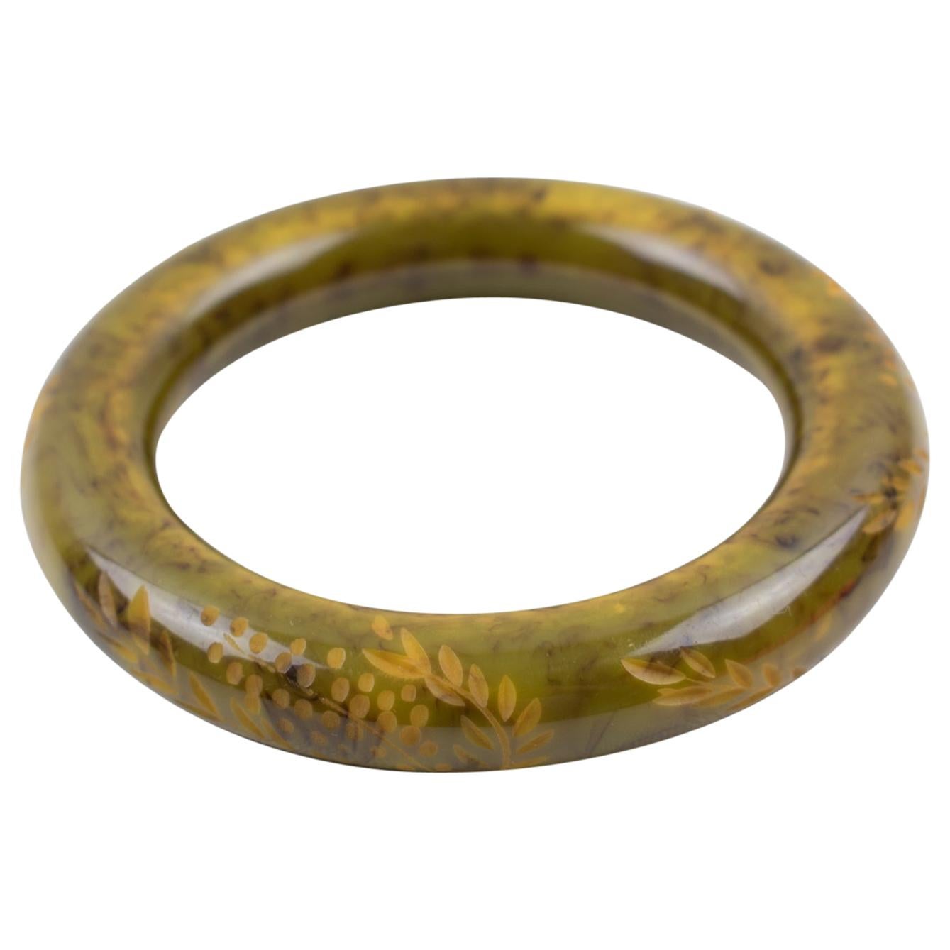 This amazing asparagus green and black marble Bakelite bracelet bangle has a chunky, rounded domed shape with deep floral carving all around it. The piece boasts an intense light asparagus green marble color with black and yellow cloudy
