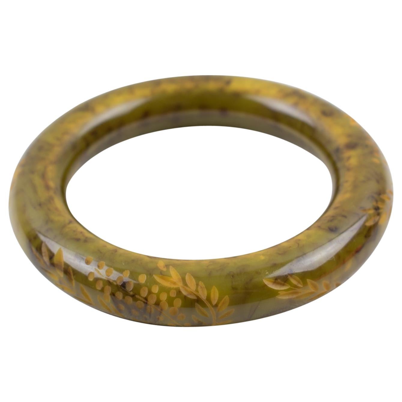 Ce fabuleux bracelet en bakélite vert asperge et noir présente une forme arrondie et bombée avec de profondes sculptures florales. Il présente une couleur marbrée vert asperge clair intense avec des tourbillons nuageux noirs et jaunes.
Mesures : Le