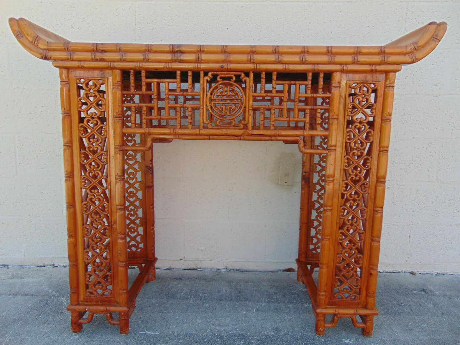 Stunning and unusual altar table or pagoda console with everted ends features intricately carved faux bamboo and open fretwork on the apron and legs, along with a Chinese Chippendale pattern on the sides. At 39 inches high, it is a wonderful piece