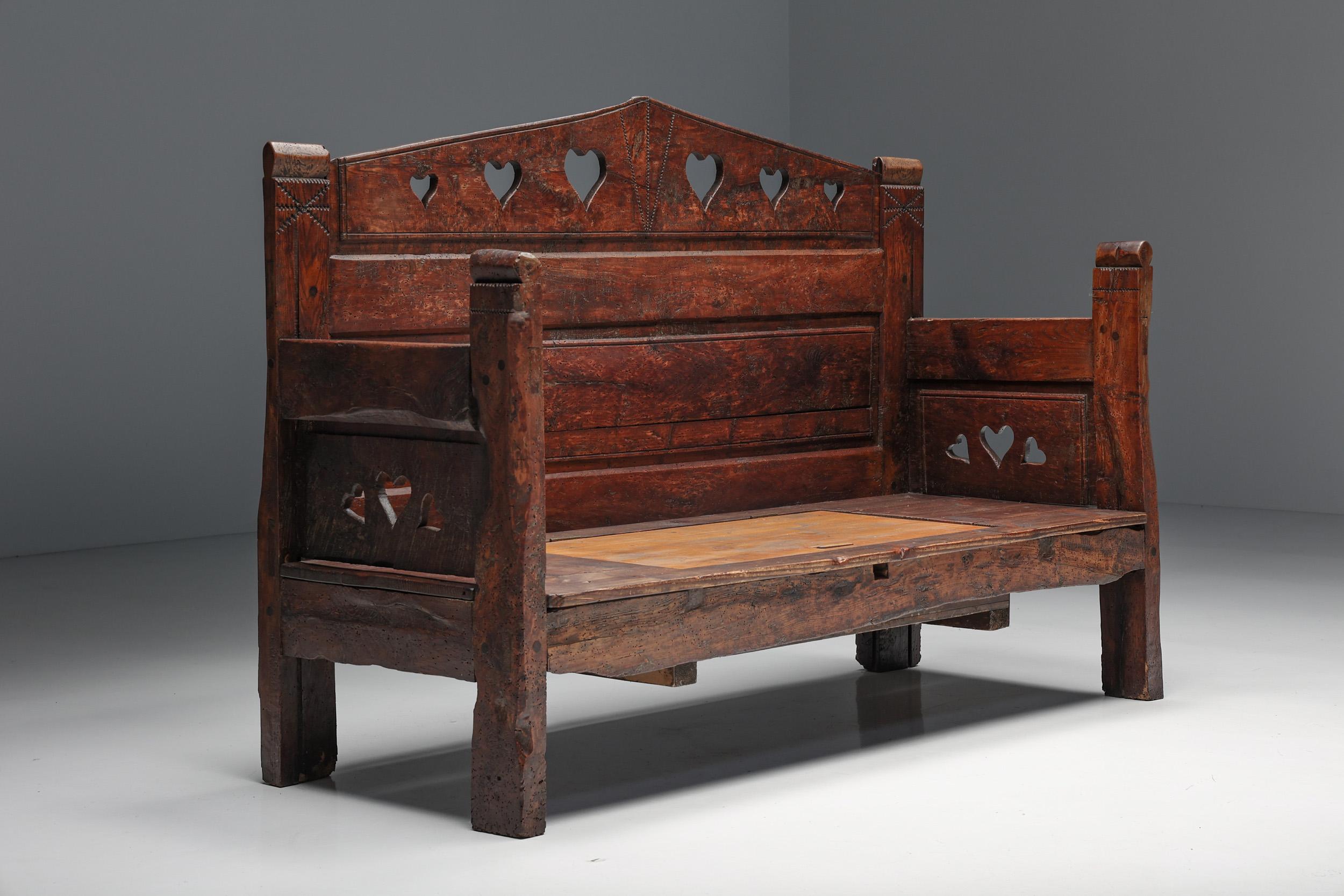 Transport yourself to the 19th century with this exquisite rustic three-seater bench, hailing from either Haute-Savoie, Breton, or Auvergnat regions. The rich patina adorning the monoxylite wood is a testament to the storied history of this