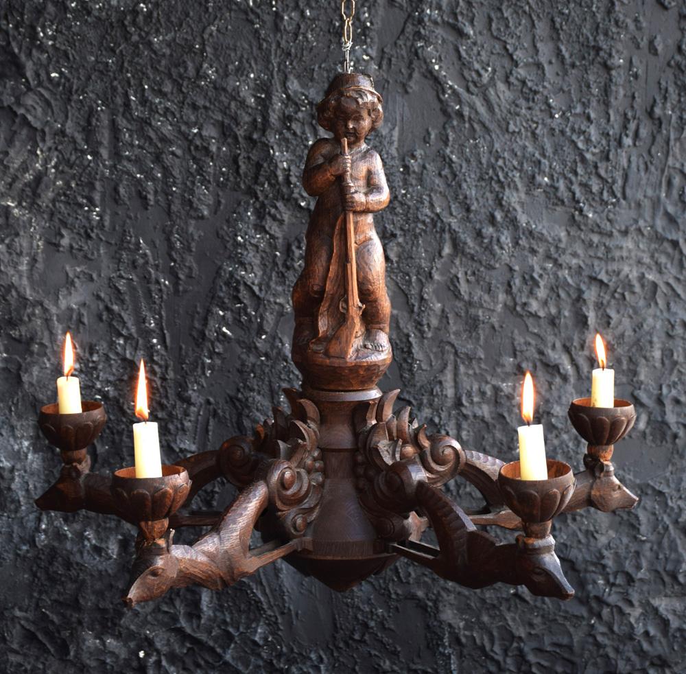 Carved wooden German chandelier, circa 1930.
We are proud to offer a rare 1930 German carved wood 5 branch chandelier, depicting a young boy with rifle and 5 stylized deer candle holders. Hand Carved, showing some detail across the entire item,