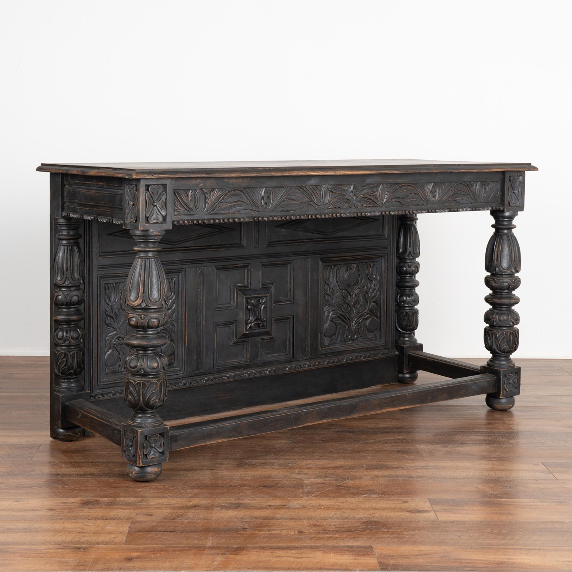Heavily carved oak console, can be used as an impressive buffet, counter or standing bar.
Note the extensive hand-carving throughout which is complimented by the newer, professionally applied black painted finish. Lightly distressed, it enriches the