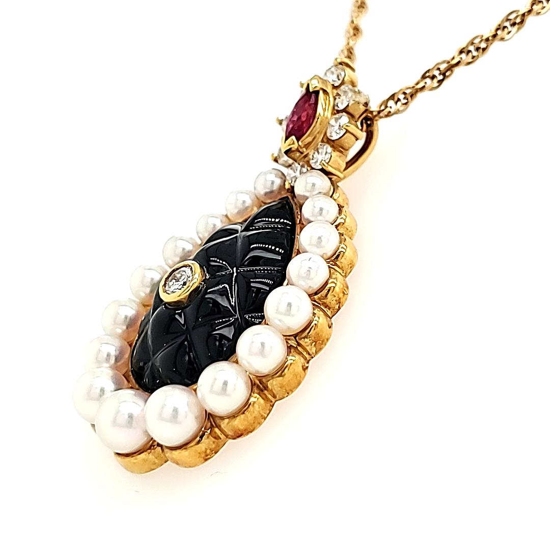 Radiate opulence with the strikingly carved black onyx centerpiece, complemented by 17 freshwater pearls delicately encircling its elegance.

Atop the onyx, a vibrant ruby weighing 0.20 cts adds a touch of color and allure, and it is accentuated by