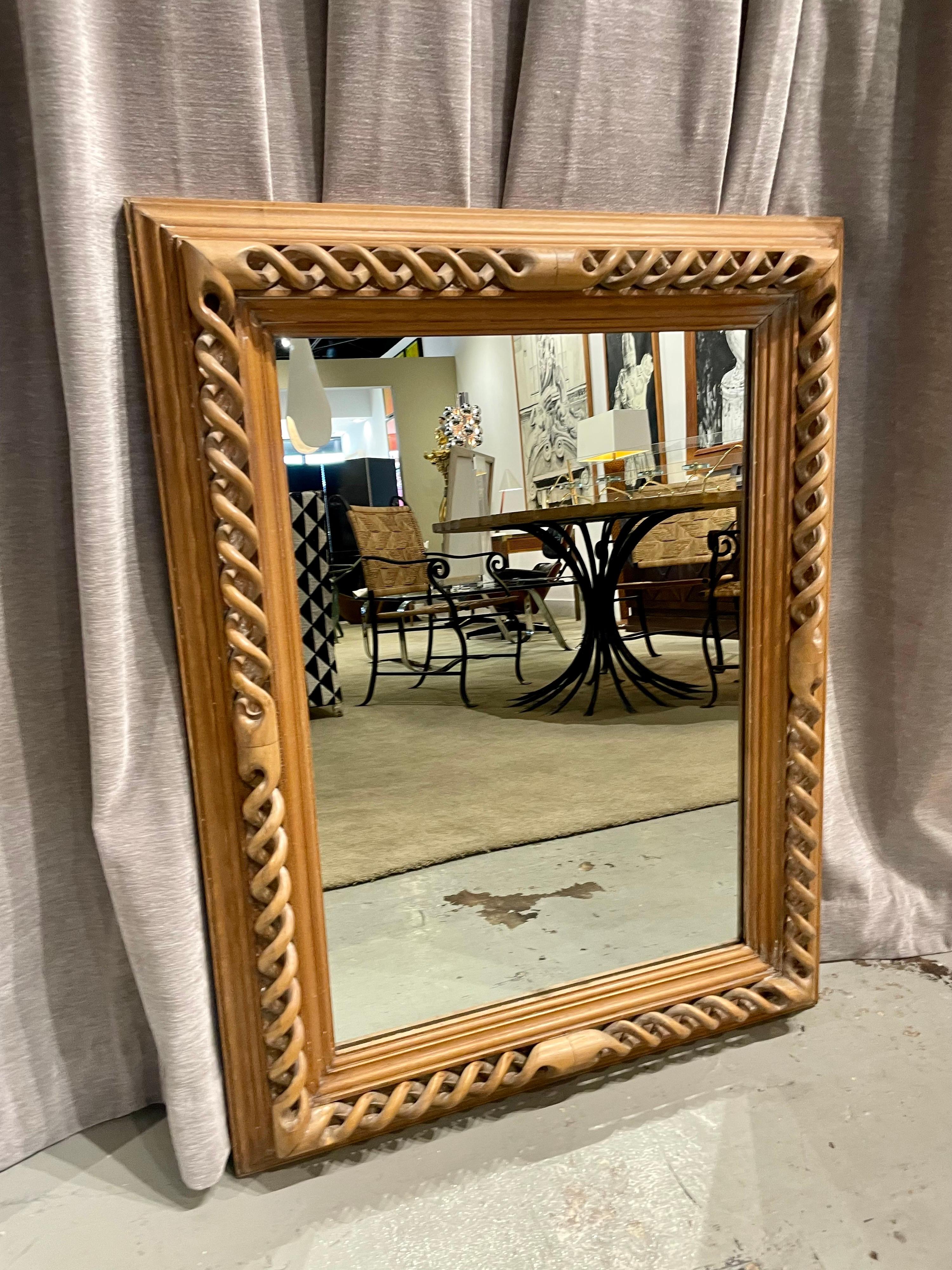 This intricately carved blonde wood mirror frame shows great detail and artistry.