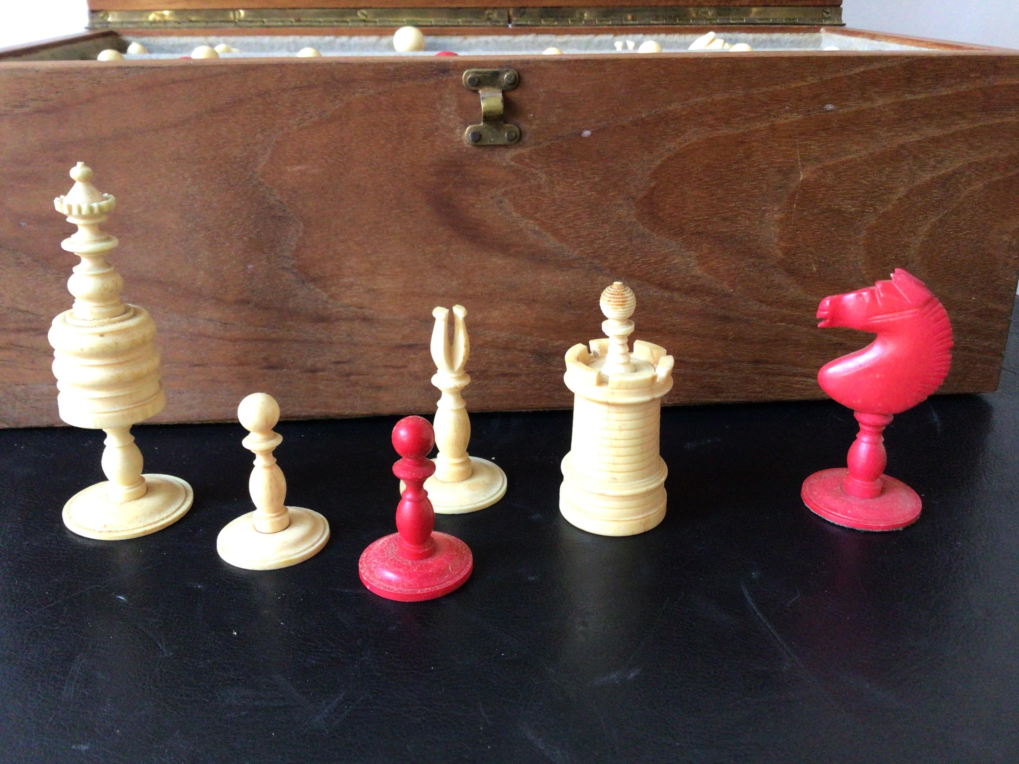 1960s Hand carved bone chess pieces set. The red pieces are dyed bone. Comes in a wood carrying case.