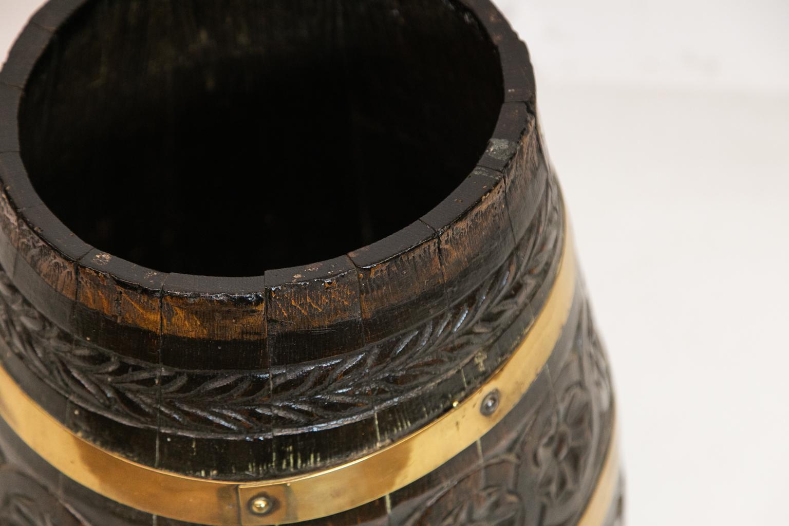 Carved brass bound barrel, with leaves and rosettes carved in high relief. It likely originally had a lid.