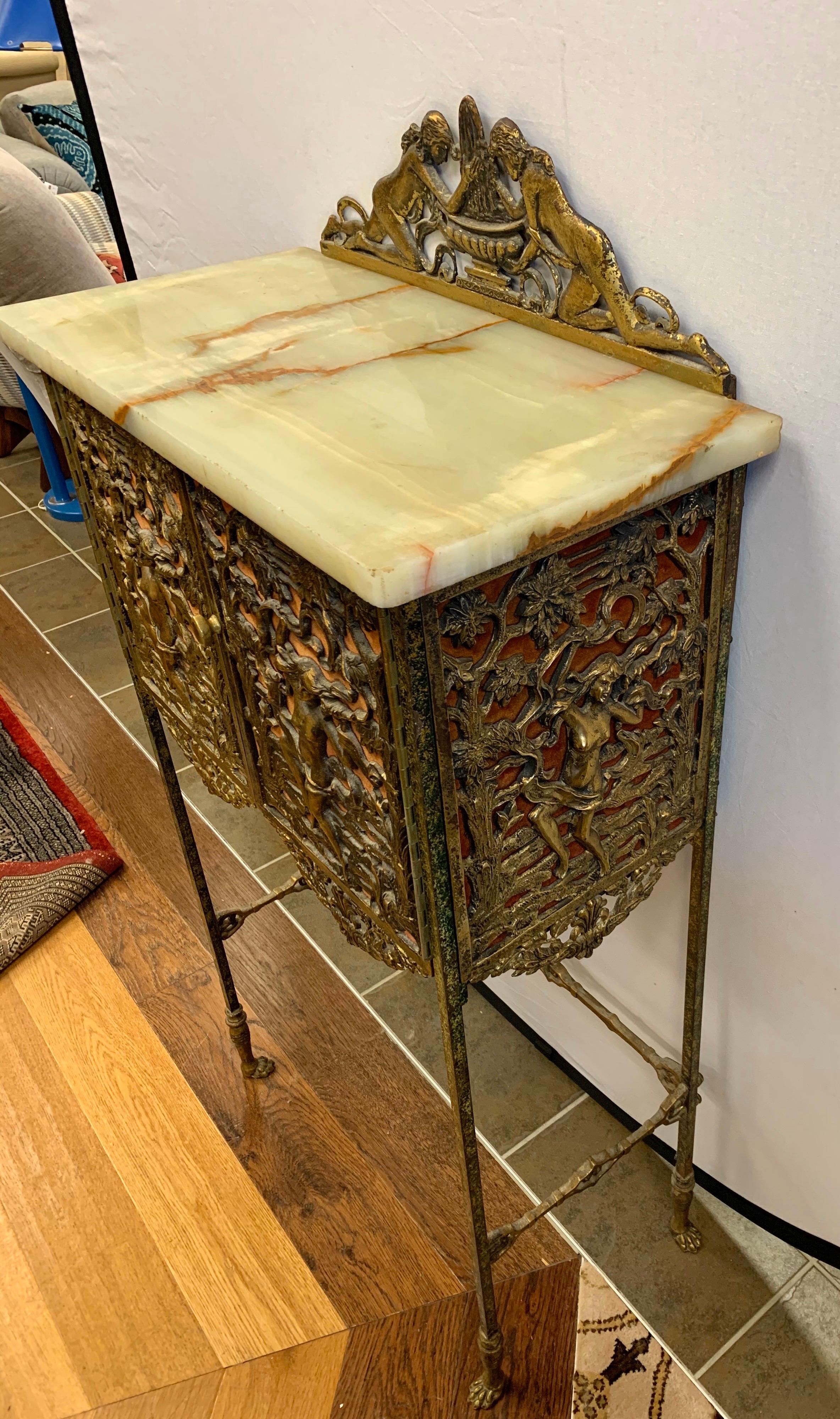 Stunning antique carved bronze Louis XVI cabinet with marble top. There are bronze carvings all around the front and left and right side. There is a secret, sliding small door in back, possibly for liquor. The marble is also in great condition with