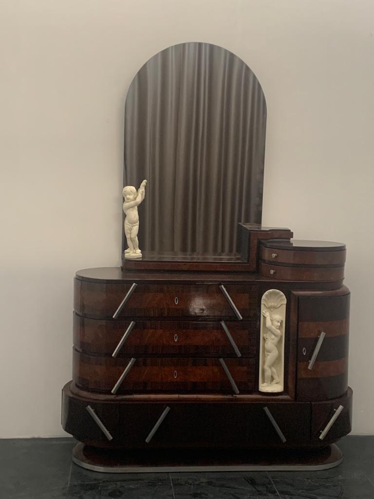 Cassettiera ovale da nave di Ducrot in palissandro con specchio e scultura in radica. 
Set di comò con specchio proveniente dalla camera da letto della suite principale del transatlantico Giulio Cesar varato nel 1920 a Palermo con il primo viaggio