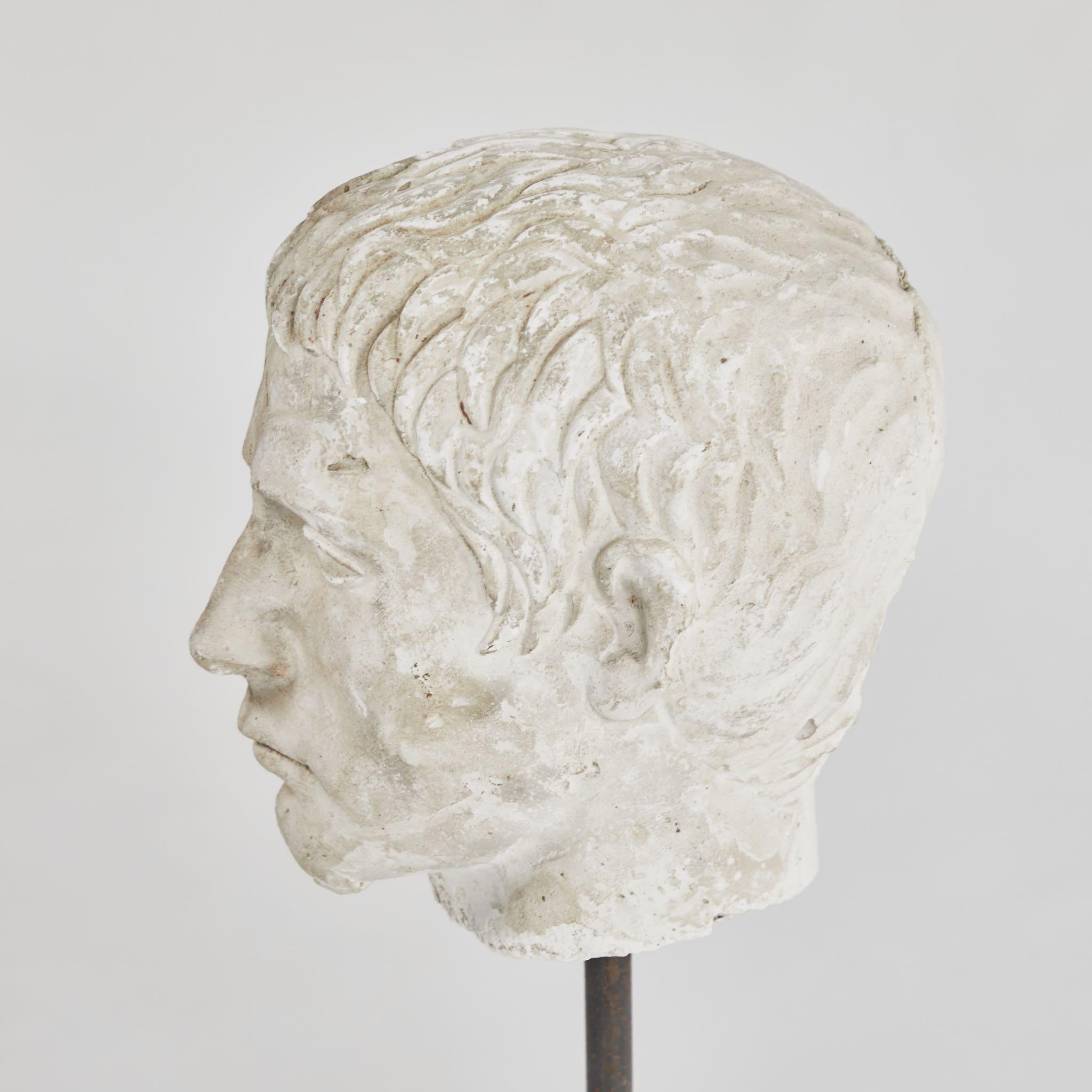 A carved bust on stand in plaster, originating in England, circa 1880.