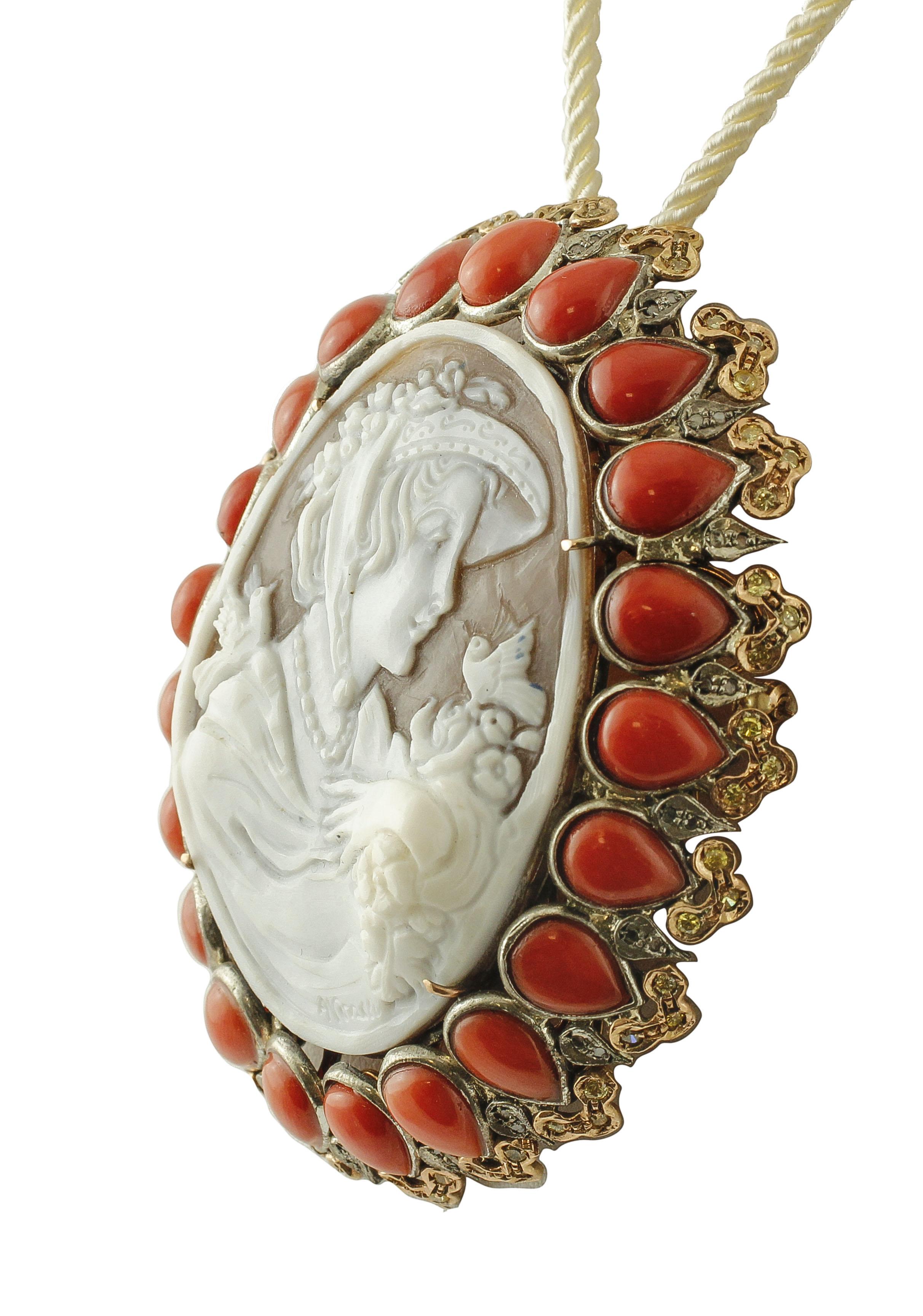 Astonishing retro brooch realized in 9k rose gold and silver. This unique brooch features a central cameo finely carved representing an elegand lady holding flowers, little drops of red rubrum coral all around, and details in silver and gold studded