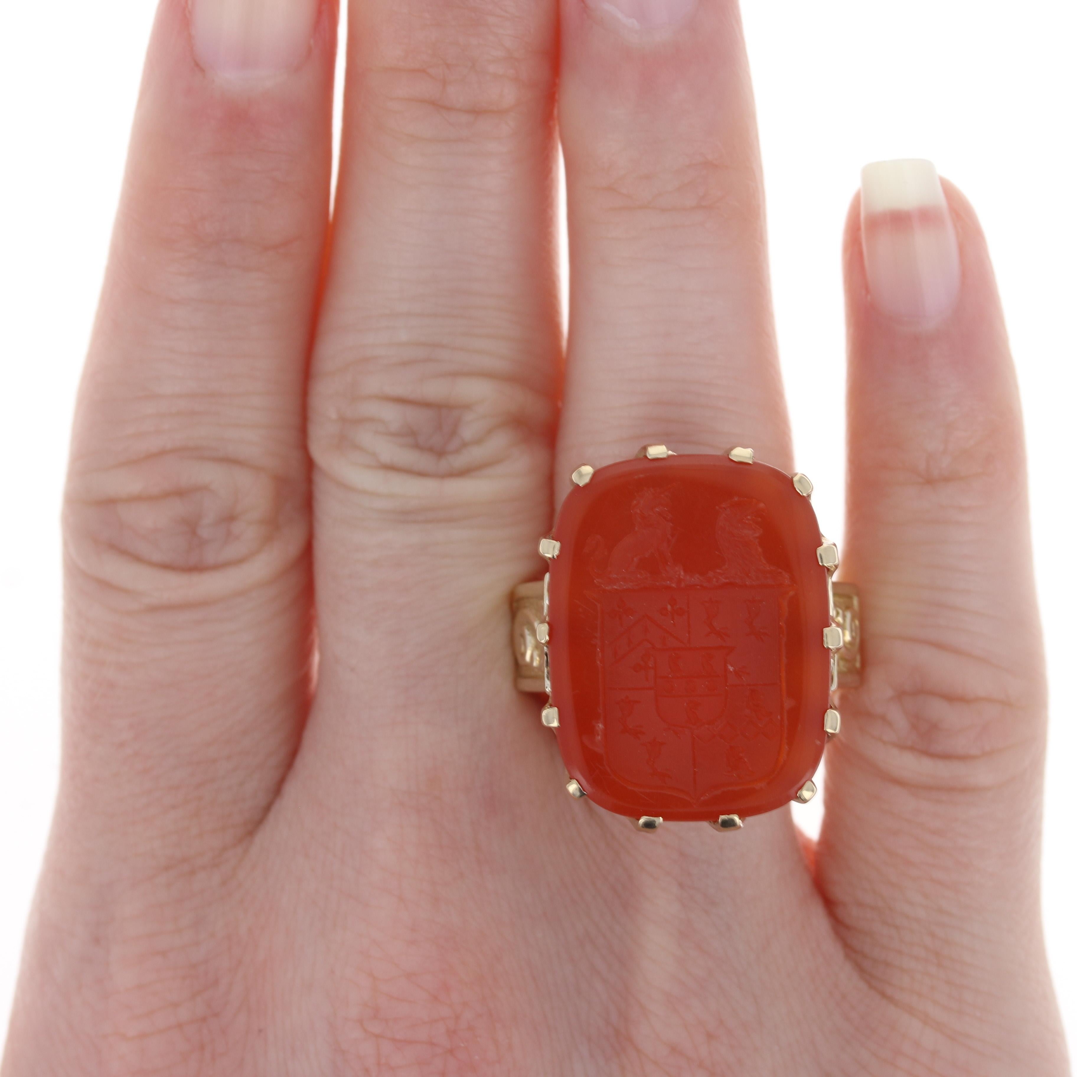 Marked by stately elegance and a bold style, this ring will be a stunning gift for the special man or woman in your life! This 14k yellow gold piece showcases a rectangular-shaped genuine carnelian that showcases an intricately carved rendering of a