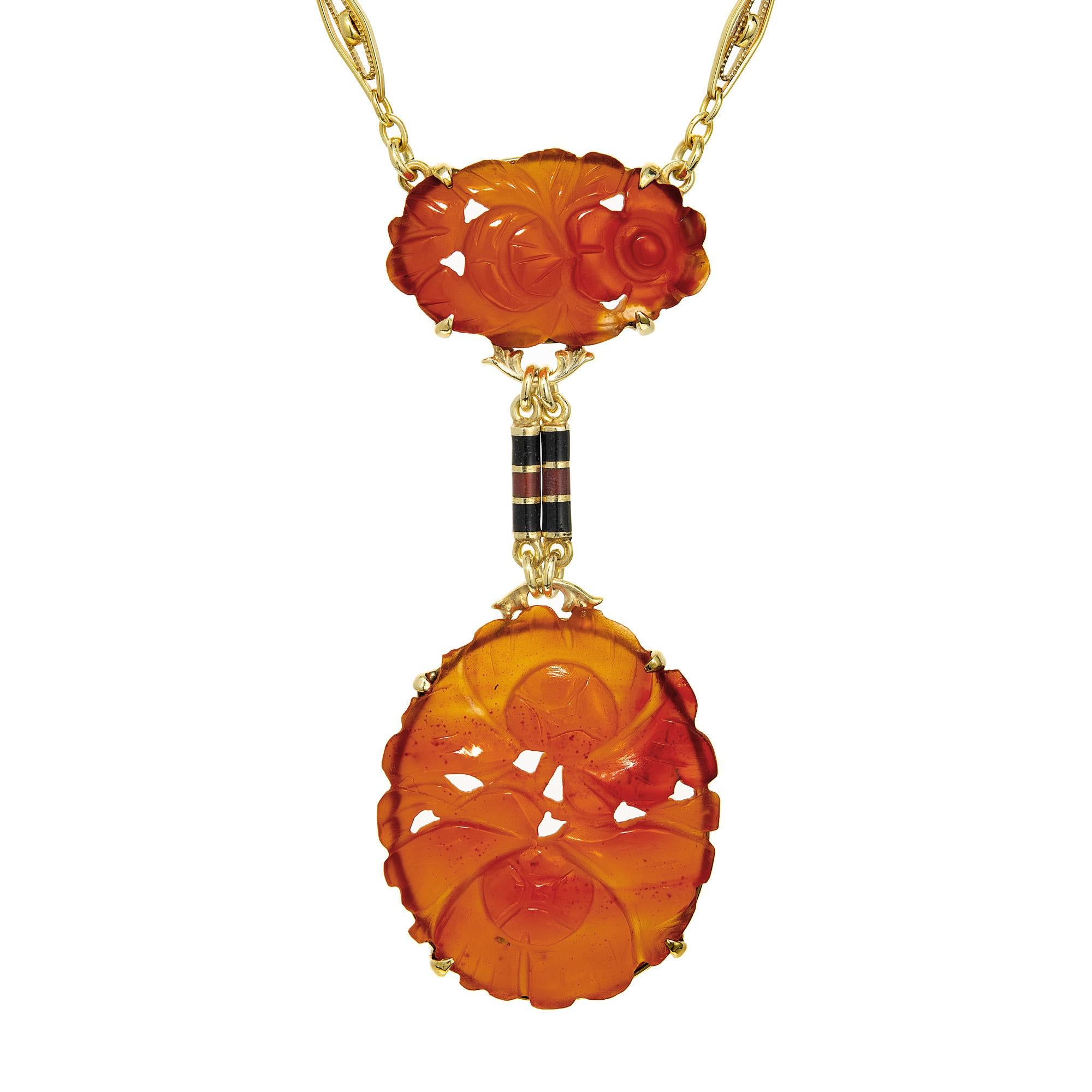 Collier à pendentifs Art déco des années 1930 en cornaline sculptée et en émail. Découvrez le luxe d'une élégance intemporelle. Deux cornalines orange taillées en ovale sont reliées par deux cylindres émaillés en or jaune 14k. Le pendentif est