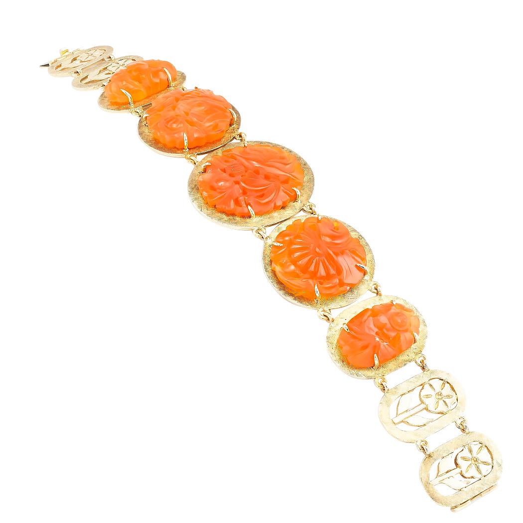 Carved carnelian and yellow gold link bracelet circa 1960.

DETAILS:

GEMSTONES:  five graduating, coin-shaped, carved, and pierced carnelian, semi translucent displaying shades burnt orange and brownish-red color.  

METAL:  14-karat yellow