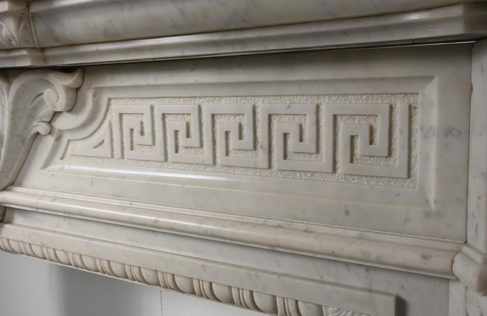 French Carved Carrara marble mantel in the Napoleon III style with winged lions For Sale