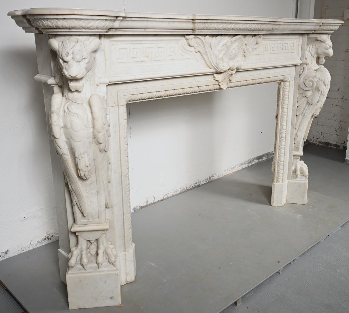 Hand-Carved Carved Carrara marble mantel in the Napoleon III style with winged lions For Sale