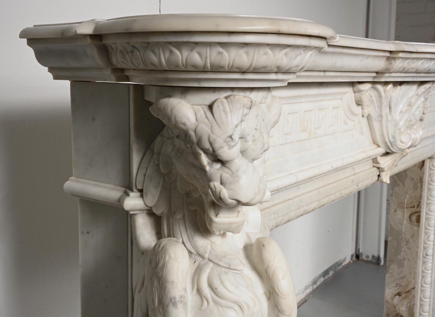 Carved Carrara marble mantel in the Napoleon III style with winged lions For Sale 1