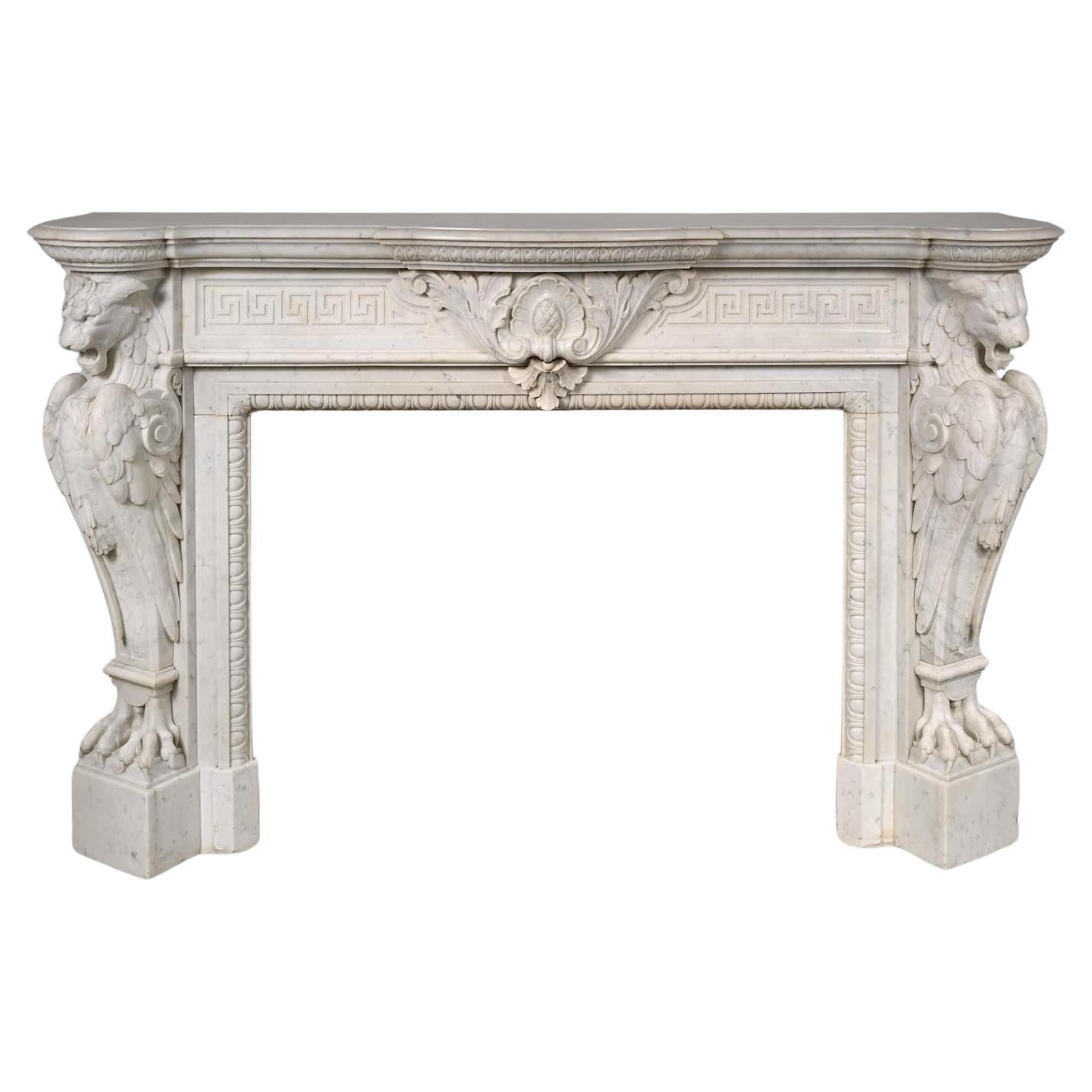 Carved Carrara marble mantel in the Napoleon III style with winged lions For Sale