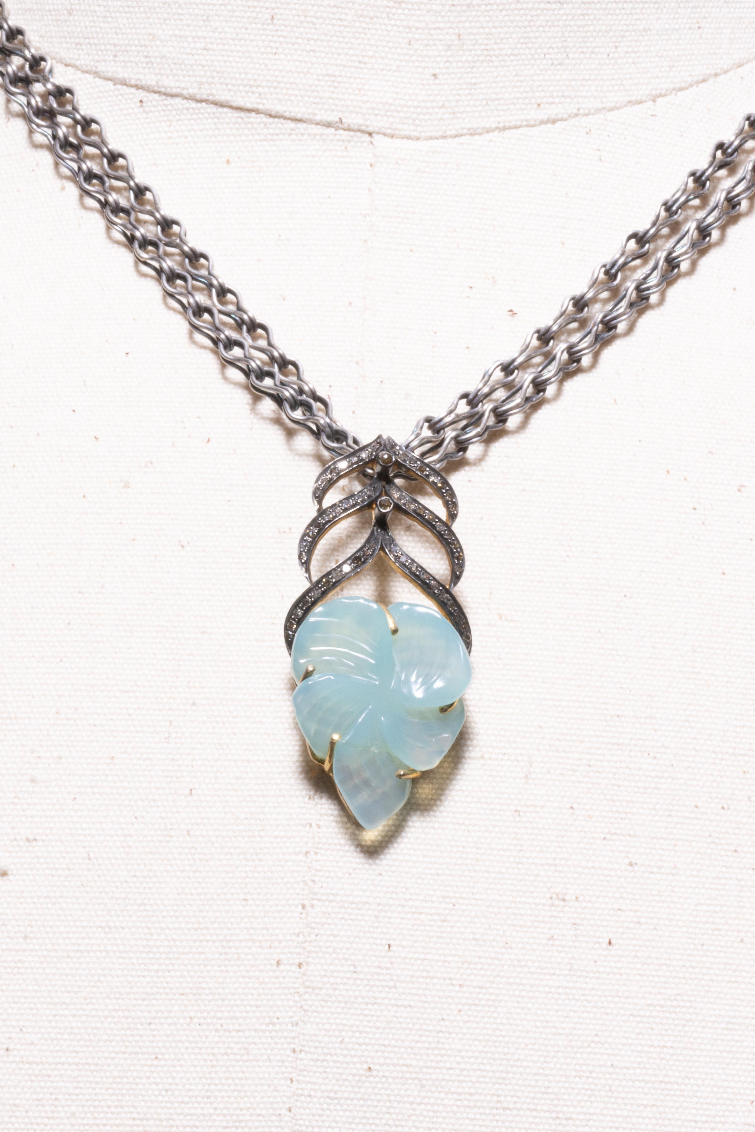 Geschnitzter floraler Chalzedon-Anhänger mit eingefassten Diamanten in oxidiertem Sterlingsilber an einer handgeflochtenen Schlangenkette aus Sterlingsilber.  Das Gewicht des Diamanten beträgt 1,47 Karat und das des Chalzedons 16 Karat.  Der