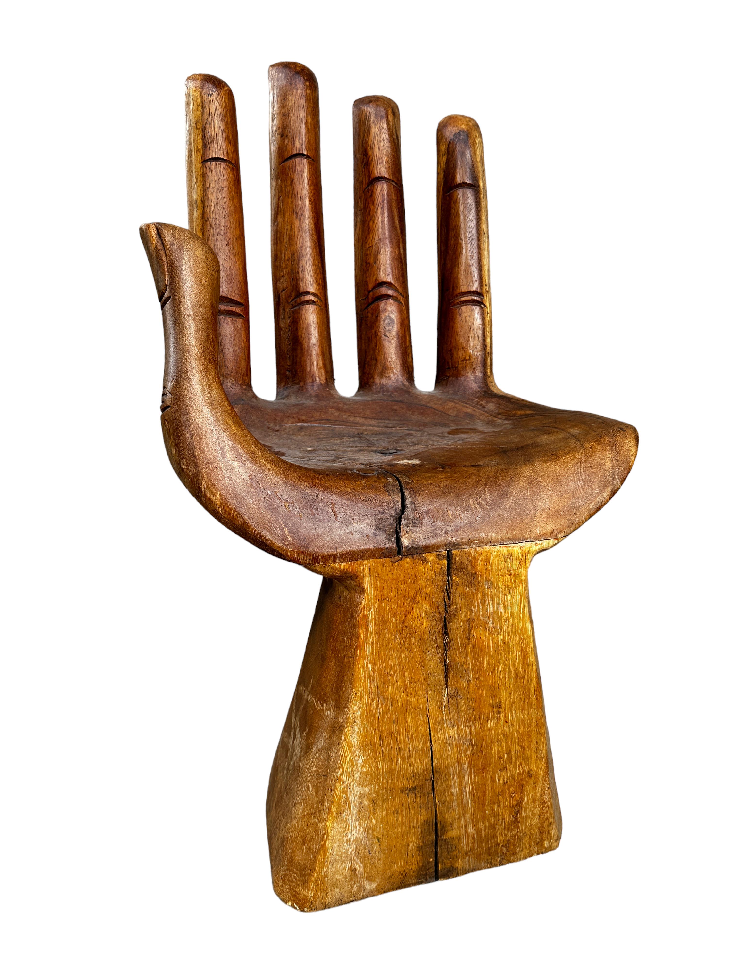 An amazing Mid-Century Modern finely detailed studio carved hand chair, circa 1970s, in the Style of Pedro Friedeberg, that brings both a meditative element and a unique functional sculpture into your home with the artisan crafted wood Carved Hand
