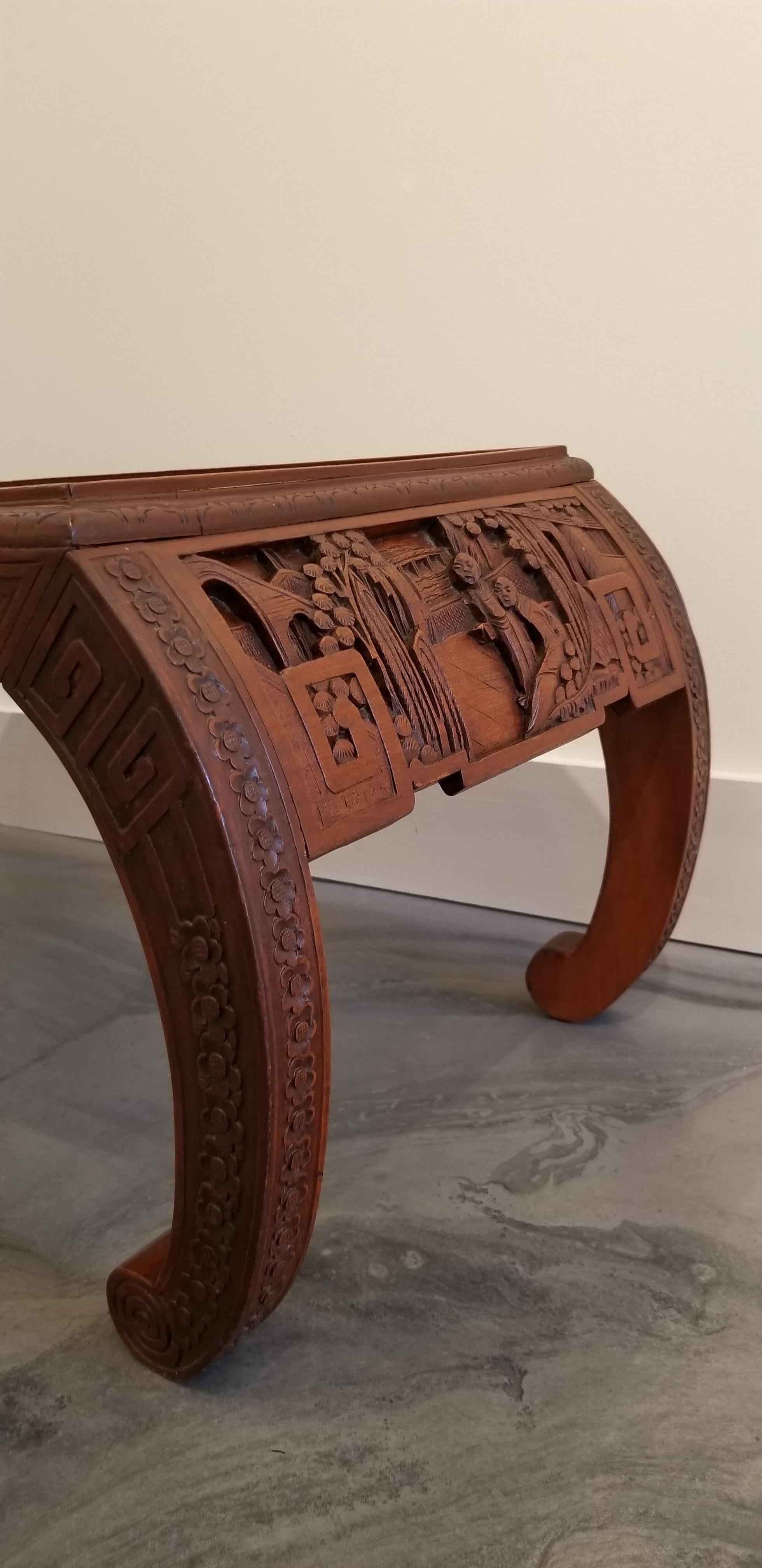 Hand-carved Chinese Ming style coffee table, circa 1950s-1960s. Nice detail to carved figures and Asian architecture with scroll work to apron and legs. Two small drawers, one on each side. Crafted in hardwood, appears to be either kiln dried teak