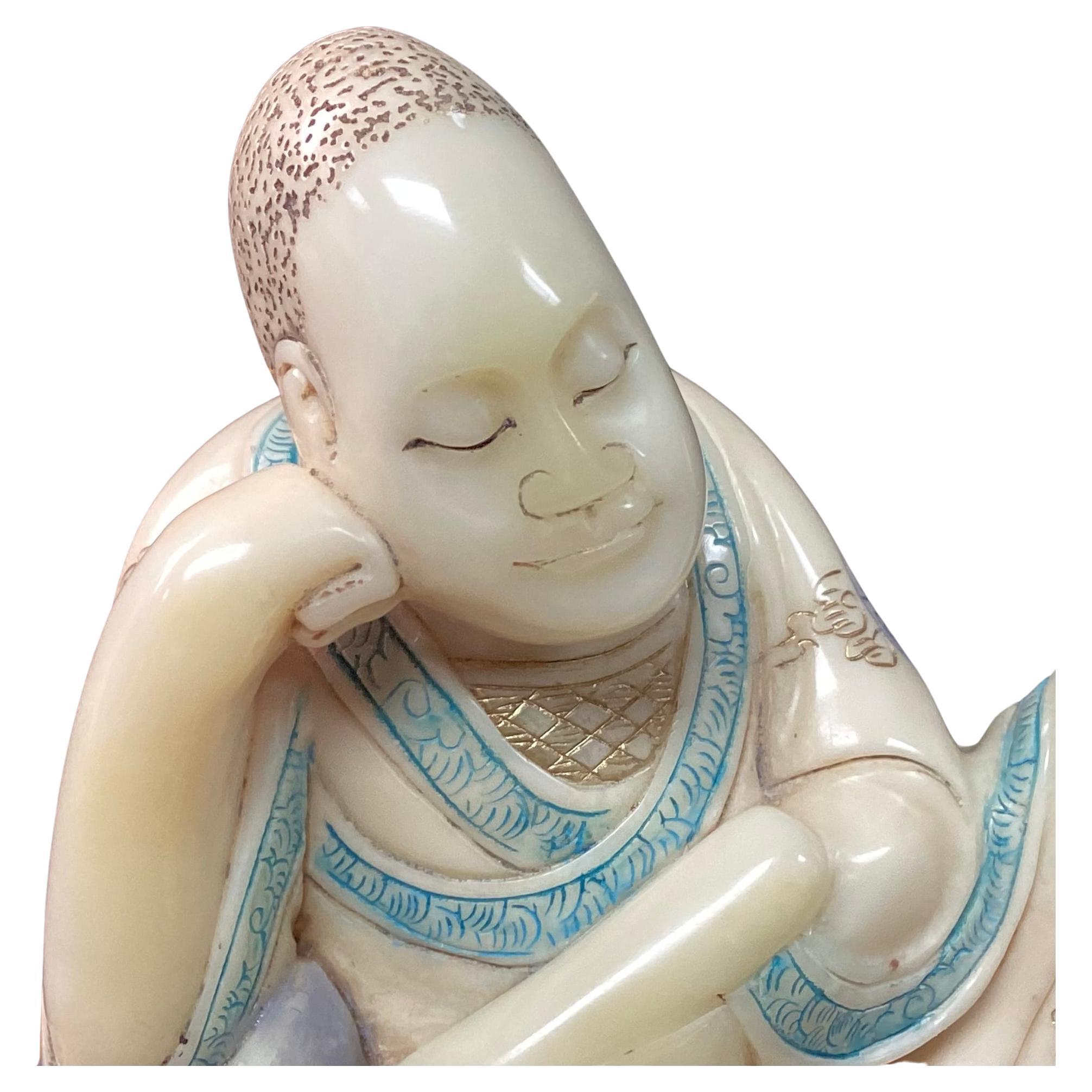 Figura de Arhat tallada en piedra de jabón china del siglo XIX, al estilo de la dinastía Qing. Figura intrincadamente tallada en posición sentada, con la mano en la cara, vestida con una túnica con símbolos de color aguamarina y azul oscuro sobre