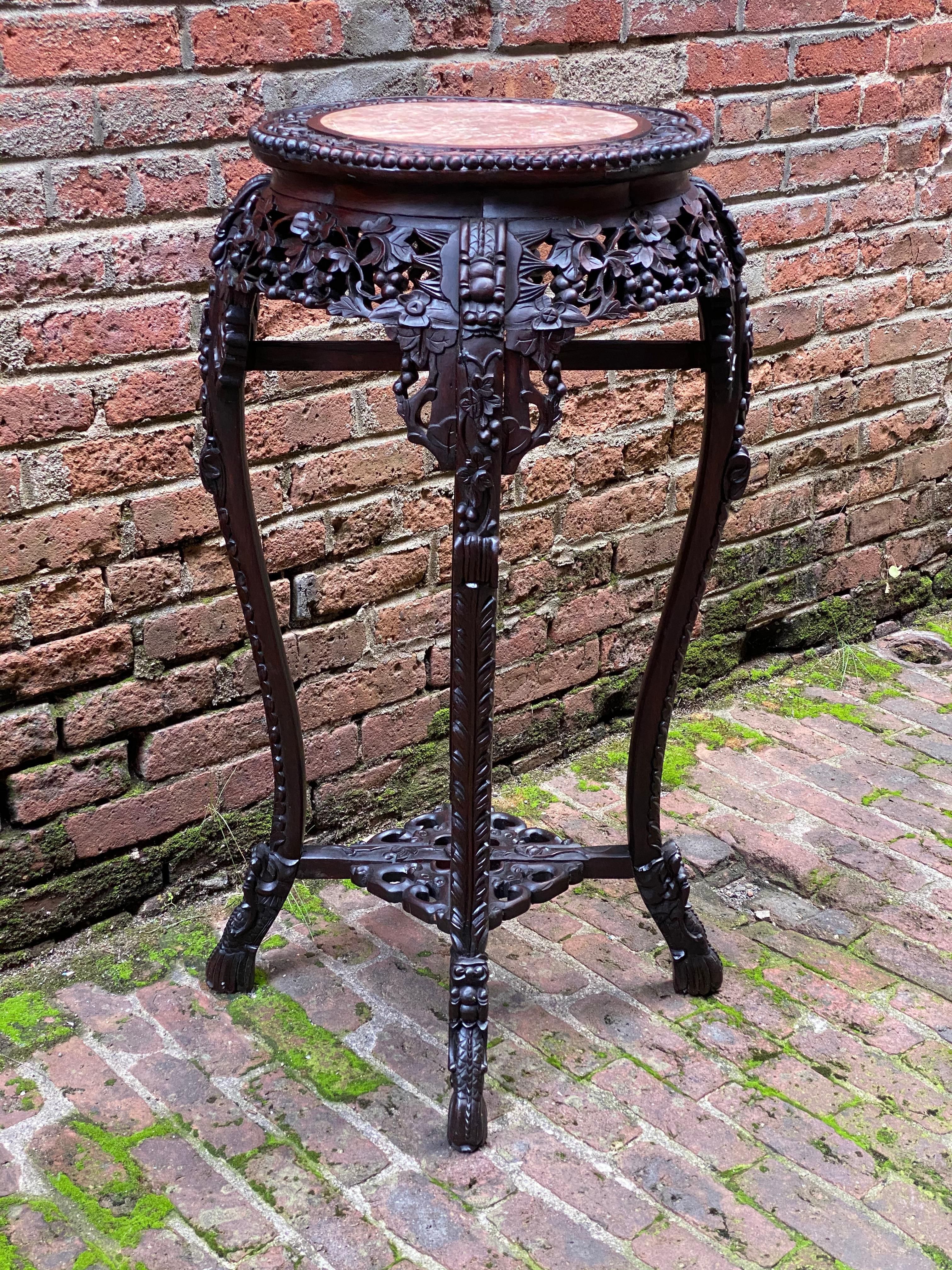 Carved Chinese rosewood and pink marble stand. Impressive detailed floral, bead and scroll carving. Featuring an inlaid pink marble top, 'S' curved legs with a stretcher base. Chinese characters on the underside, paper label and burn in mark, China,