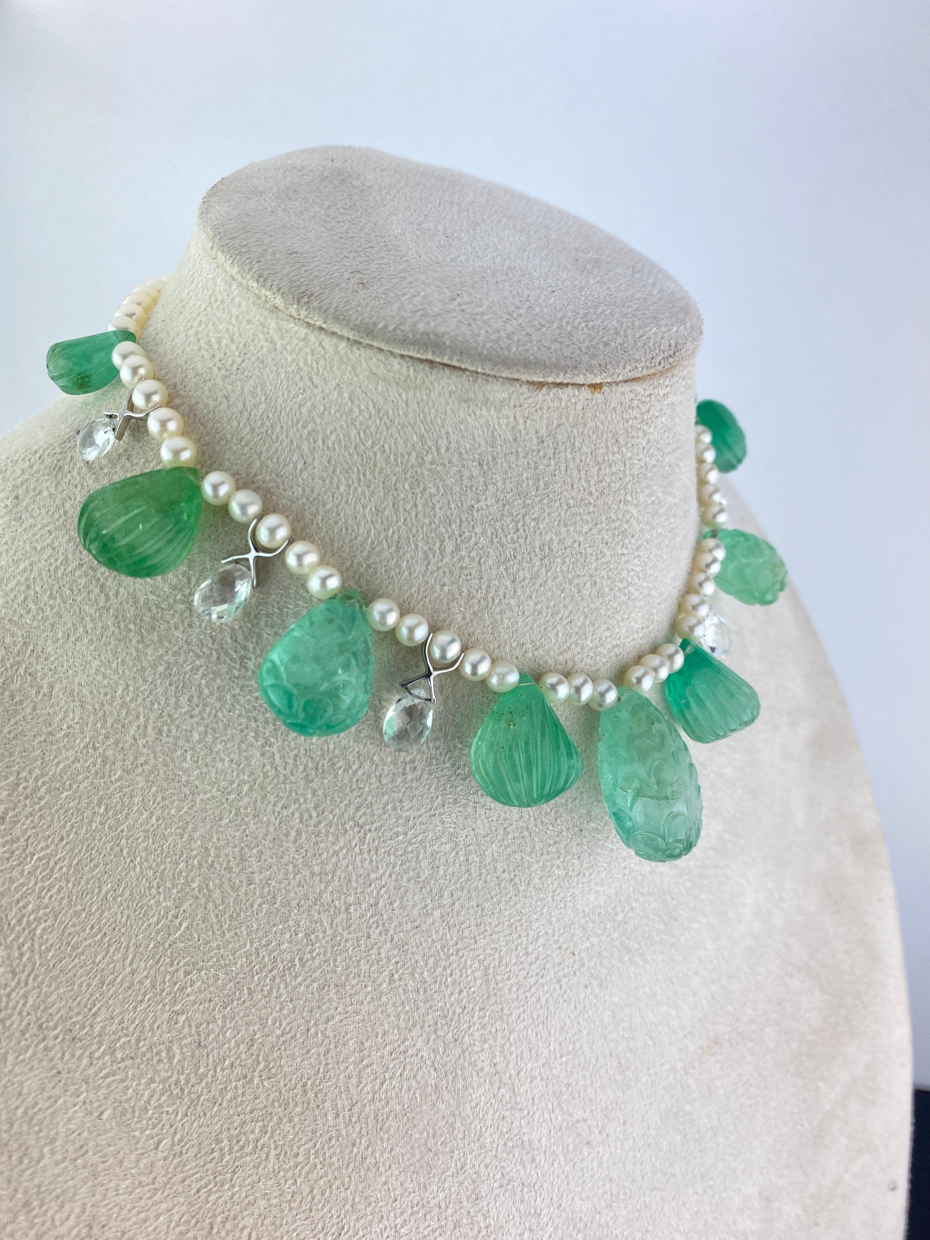 A gorgeous 135.65 carat carved transparent,  Colombian Emerald and 178.67 carat Pearl beaded necklace. The carved Emeralds give an art-deco feel to the necklace, and 8.36 carat faceted white sapphire drops adds a unique touch to it. The necklace is