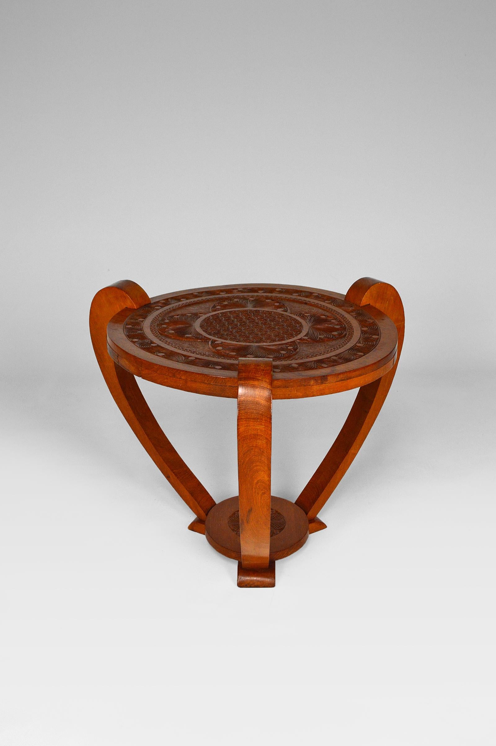 Small tripod tea or coffee table / side table in carved exotic wood.

The sculptures on the plateau represent a stylized sun surrounded by vegetation. 

Colonial Art Deco / Mid Century style, circa 1930-1940.
Country of origin unknown.

In