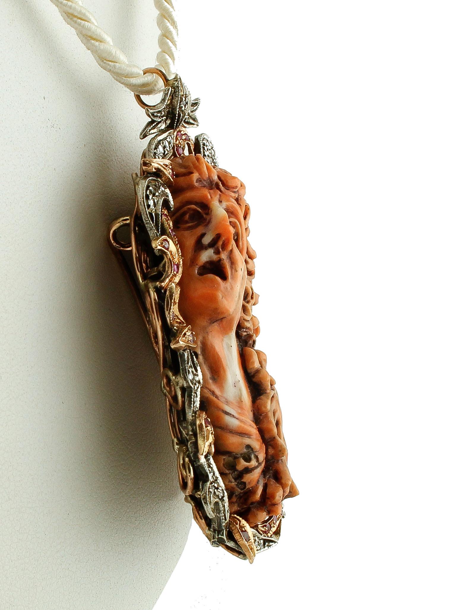Beautiful retro pendant/brooch realized with a central elatius coral finely carved , framed by a flowery structure in 9k rose gold and silver studded with little diamonds and rubies. 
This particular pendant/brooch is totally handmade by Italian