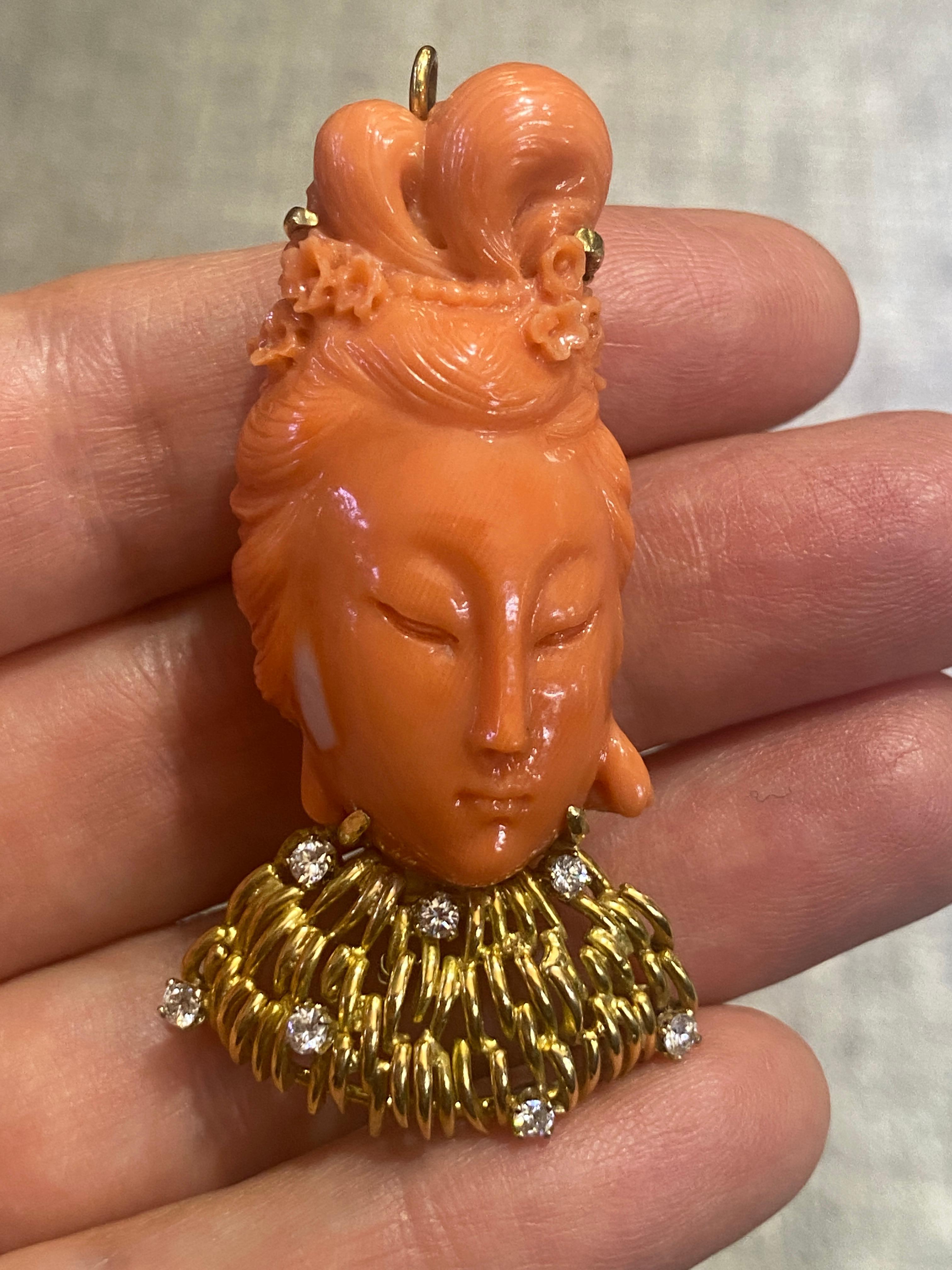 Diese schöne geschnitzte Buddha-Brosche aus Koralle hat einen zart geschnitzten Haarknoten, der mit Perlen und kleinen Blumen verziert ist. Das Halsband ist aus 14-karätigem Gold gefertigt und mit 7 Diamanten im Rundschliff von insgesamt ca. 0,35