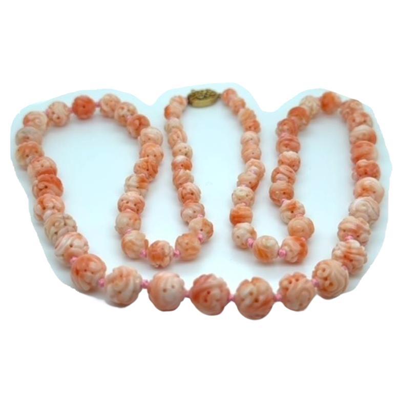 A beautiful, hand carved, Japanese pink/peach color Momo cor25-inch necklace. Each coral is exquisitely carved and pierced and strung on pink silk attached to a gold-plated silver clasp. The 71 coral beads range from 5.90 MM to 9.6MM. the beads are