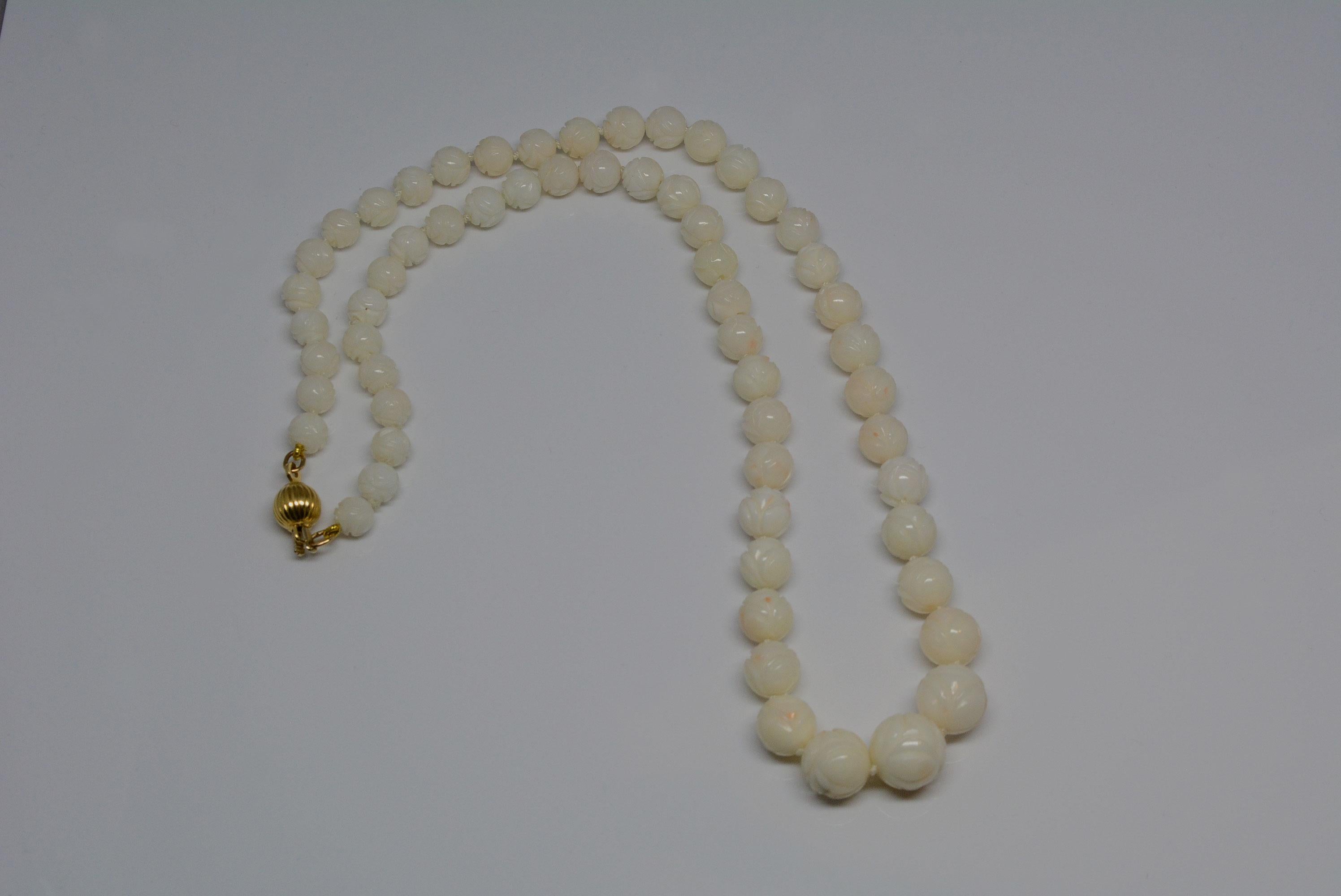
It's not every day that you come across a nice coral necklace that has beautifully carved beads. The coral is an off-white colour with pink accents on a knotted strand. 
The carved beads have a bright polish and feel nice to wear against the