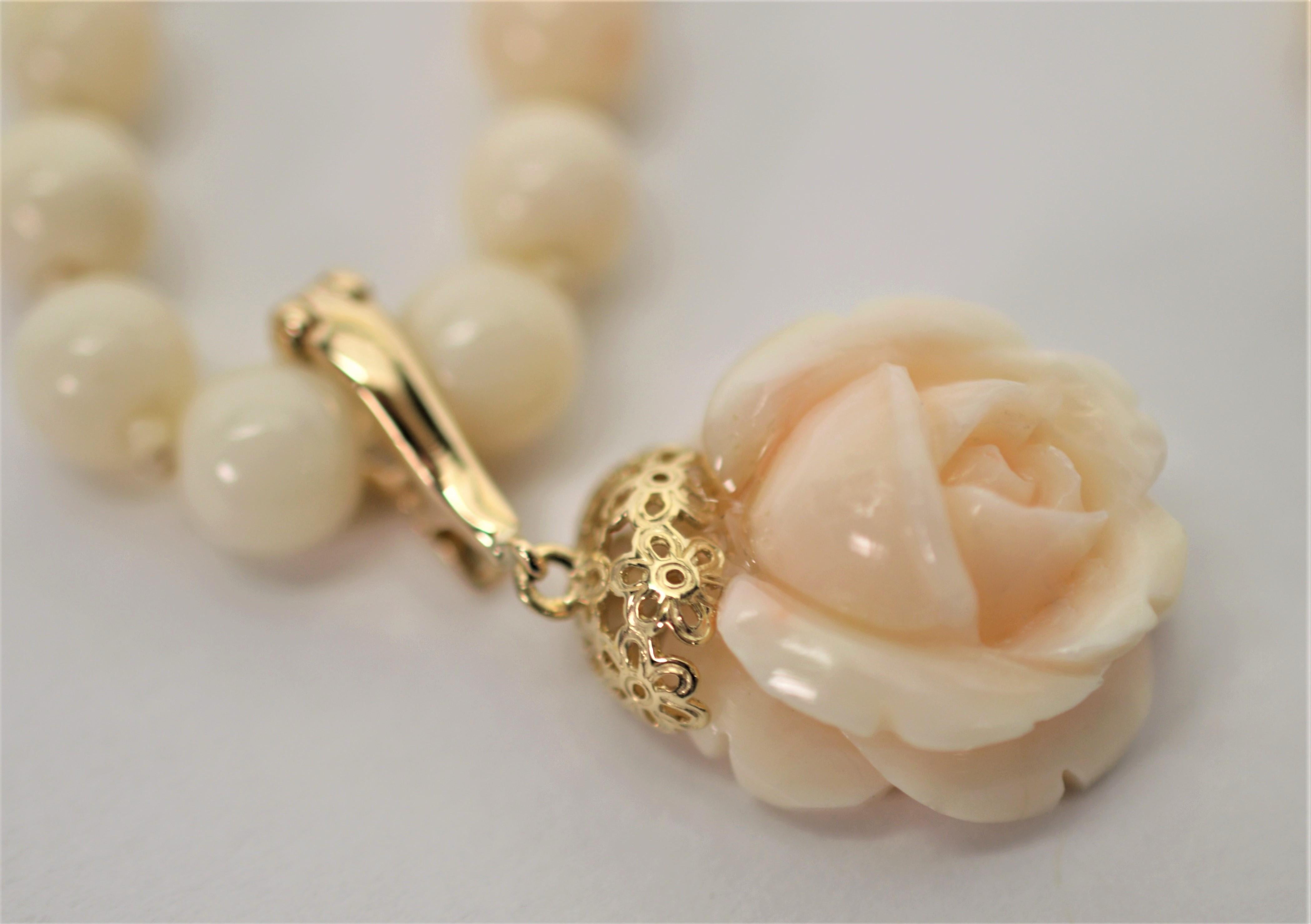 Creamy blush color 6.5 mm natural coral beads on this fourteen inch strand lead to a beautiful carved coral single rose bud pendant.
The rose bud feature measures approximately 17.5 mm. With fourteen carat gold findings, the rose pendant is fitted
