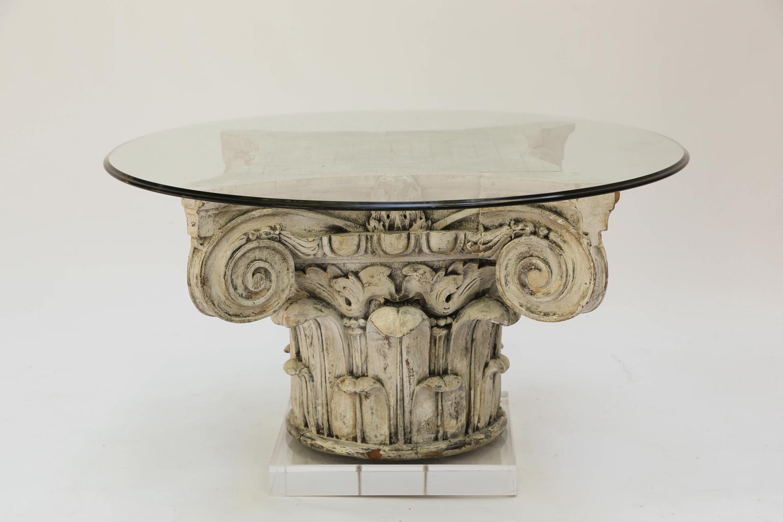 Cocktail table, having a round top of glass, its base a finely carved Corinthian capital fragment, raised on square plinth of Lucite.

Stock ID: D2636.