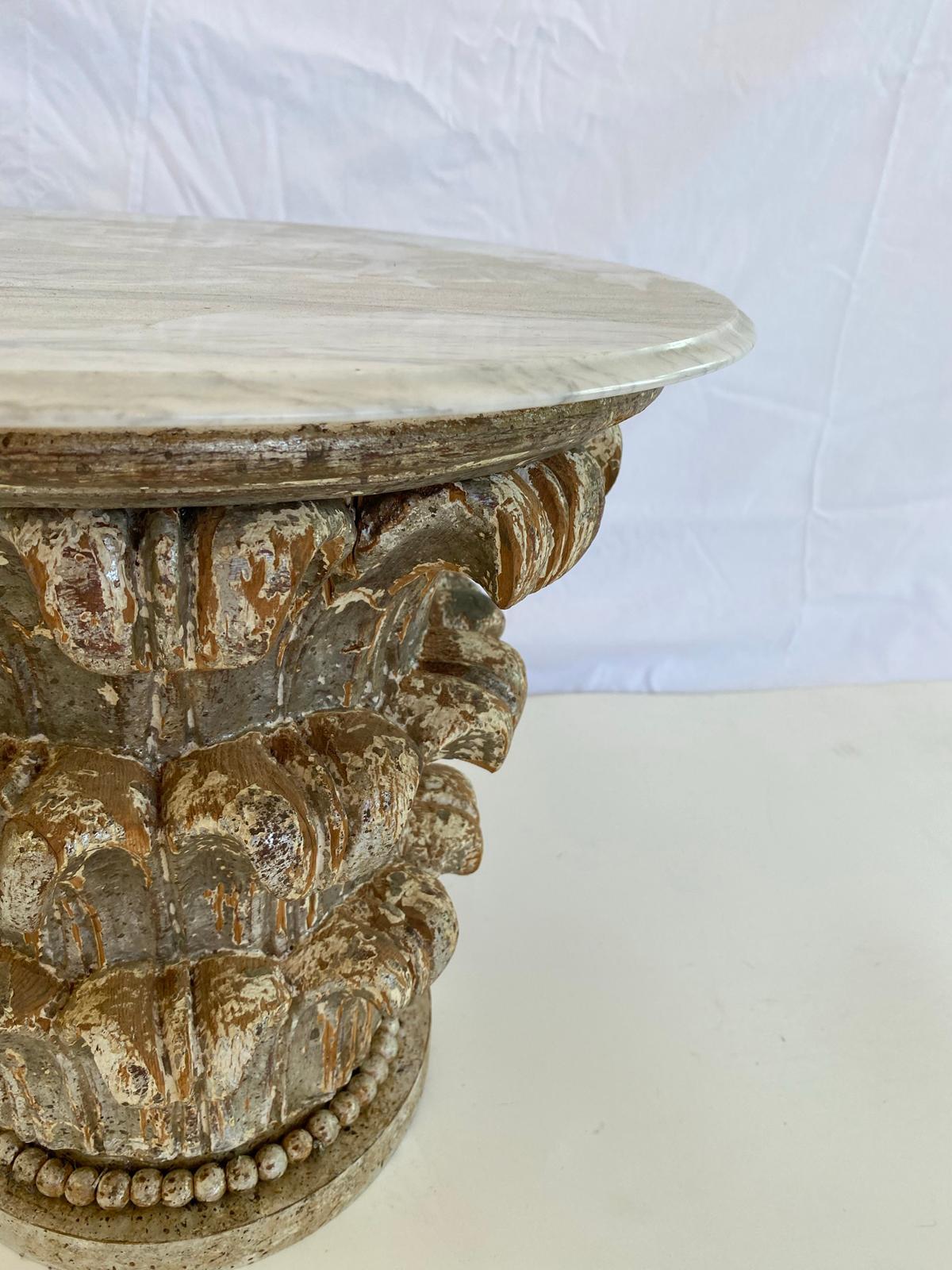 Side table, having a round top of Carrara marble, on a base of silvergiltwood, with distressed finish, carved as a Corinthian capital. 

Stock ID: D1795