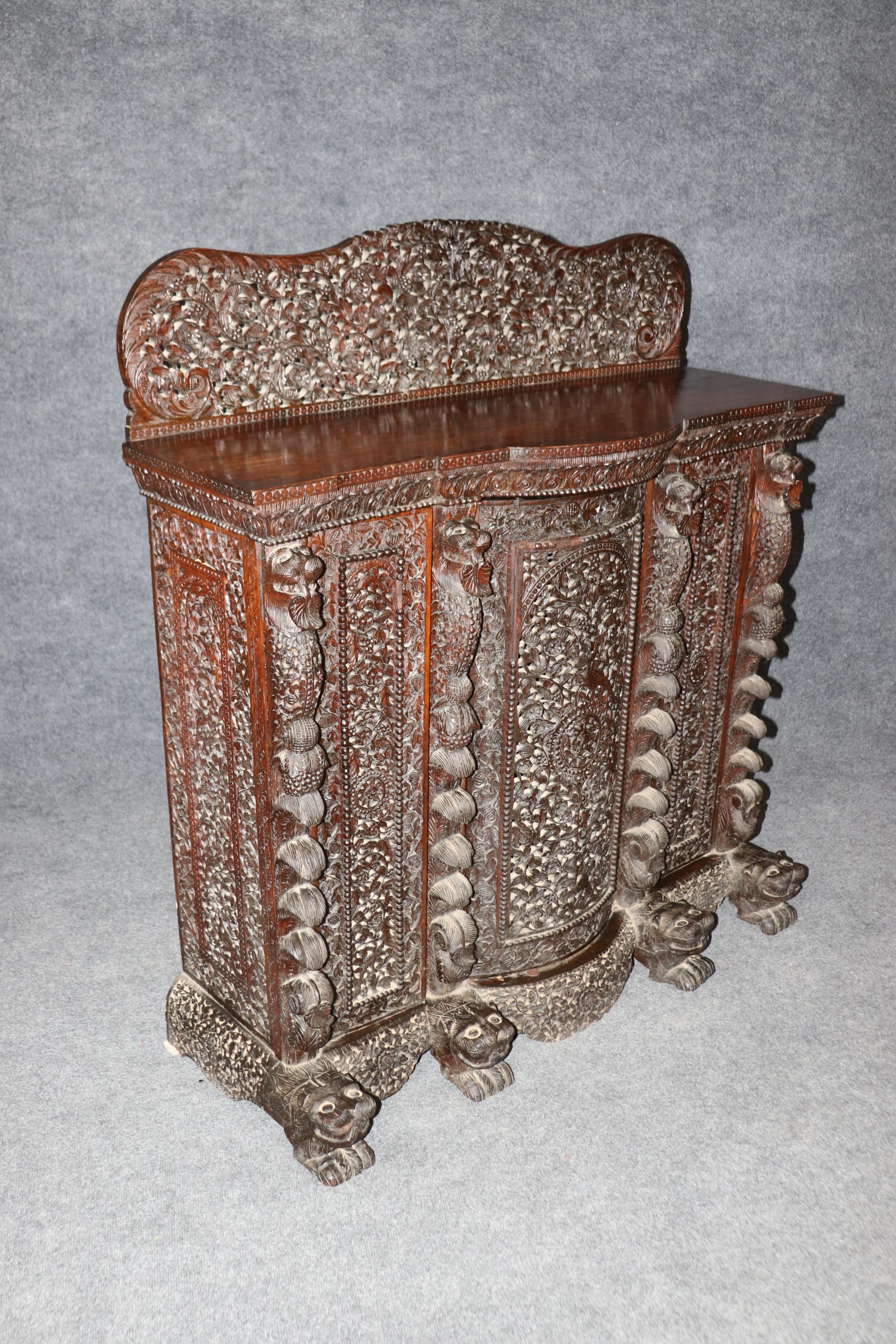 This is a carved-to-the-death solid teak Anglo-Indian buffet. The English colonized Inida for a long time and took their ideas and had the India's designers take their English designs and use their imagination in their cabinetry. The piece is in